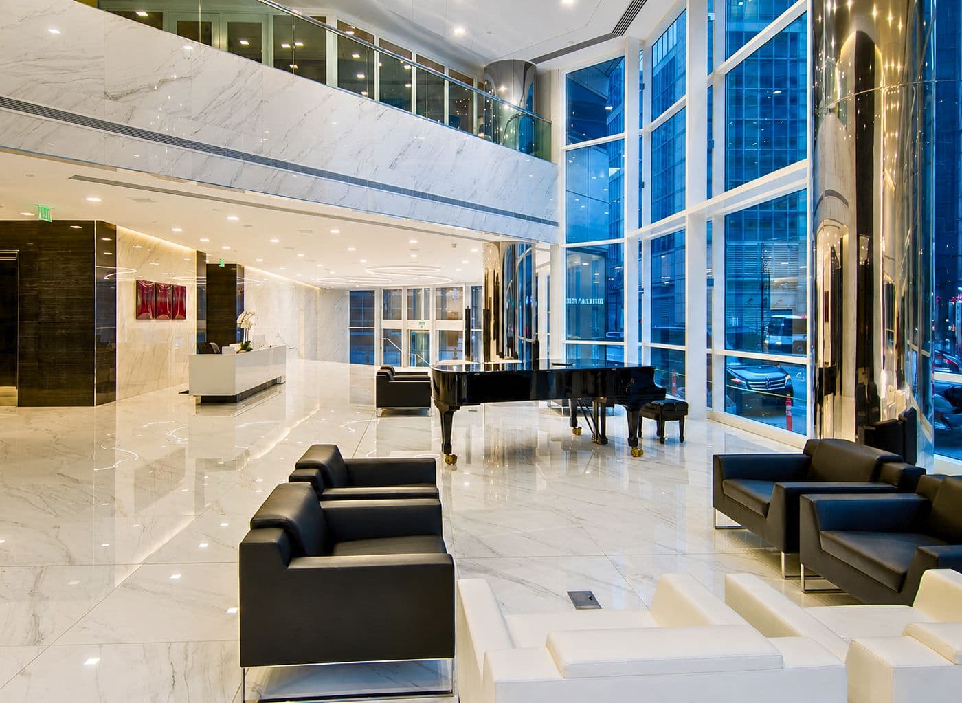 Lyric Tower lobby features floor to ceiling windows and white marble flooring .