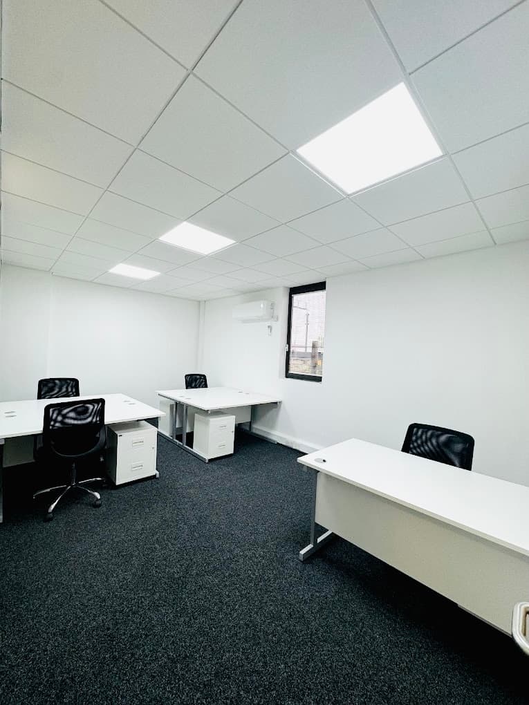 4 person spacious furnished office with windows, desks and office chairs.