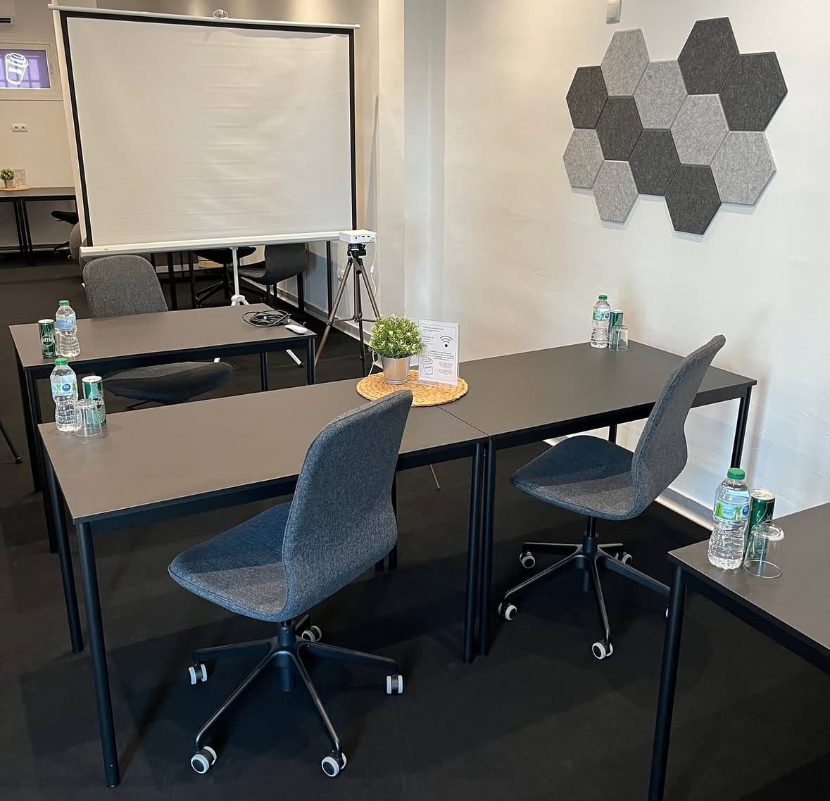 Equipped coworking area with desks and presentation screen