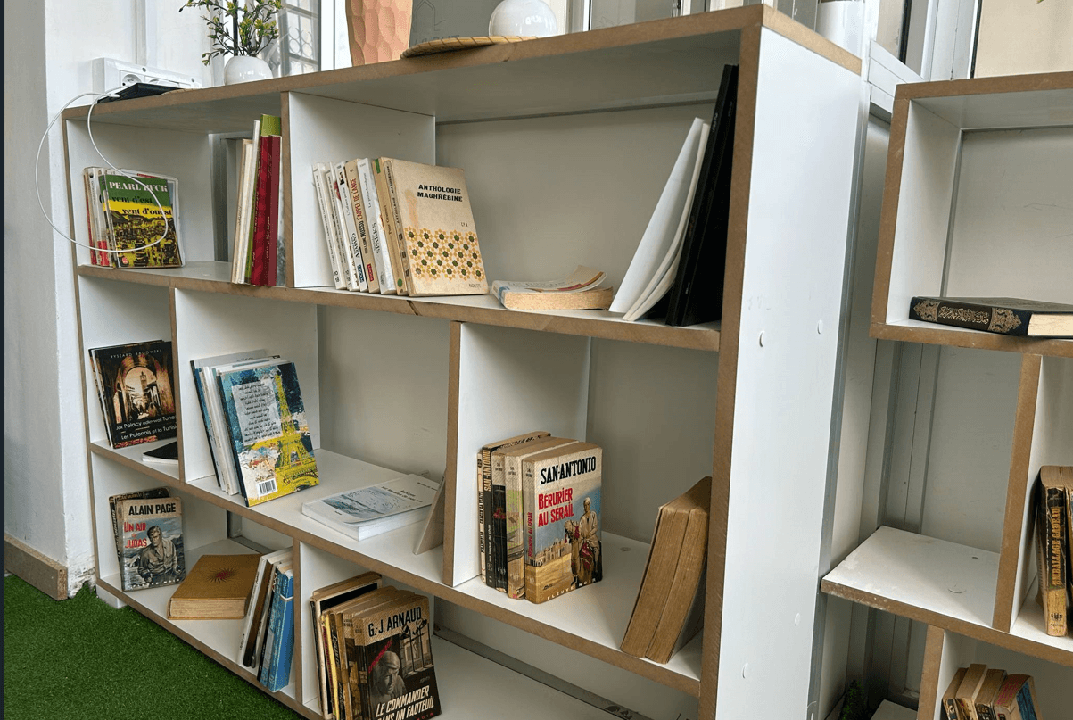 A relaxed, shared bookshelf full of donated books—stories passed from one visitor to the next.