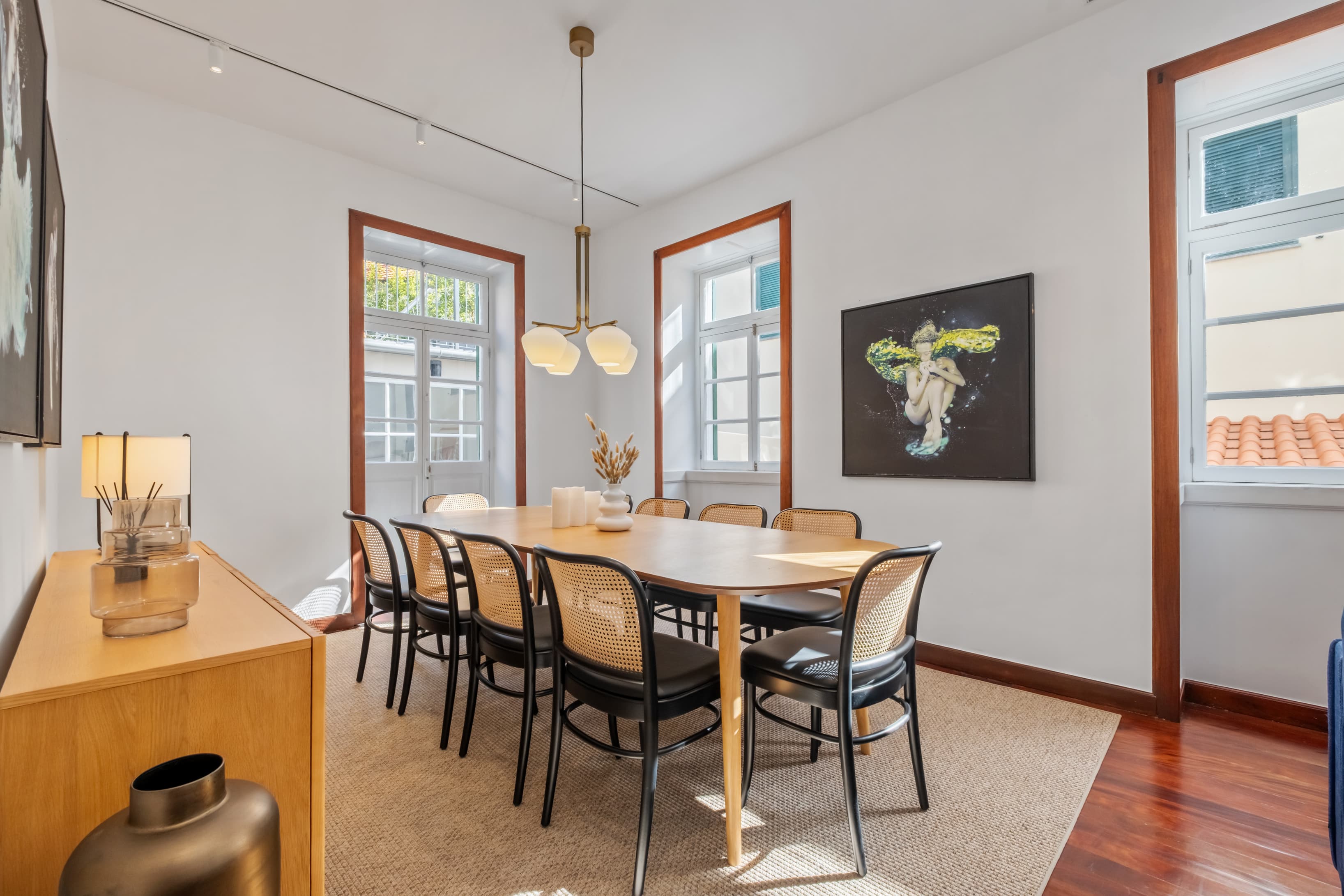 Elegant shared dining room with a large wooden table and cane chairs, perfect for community meals and gatherings.