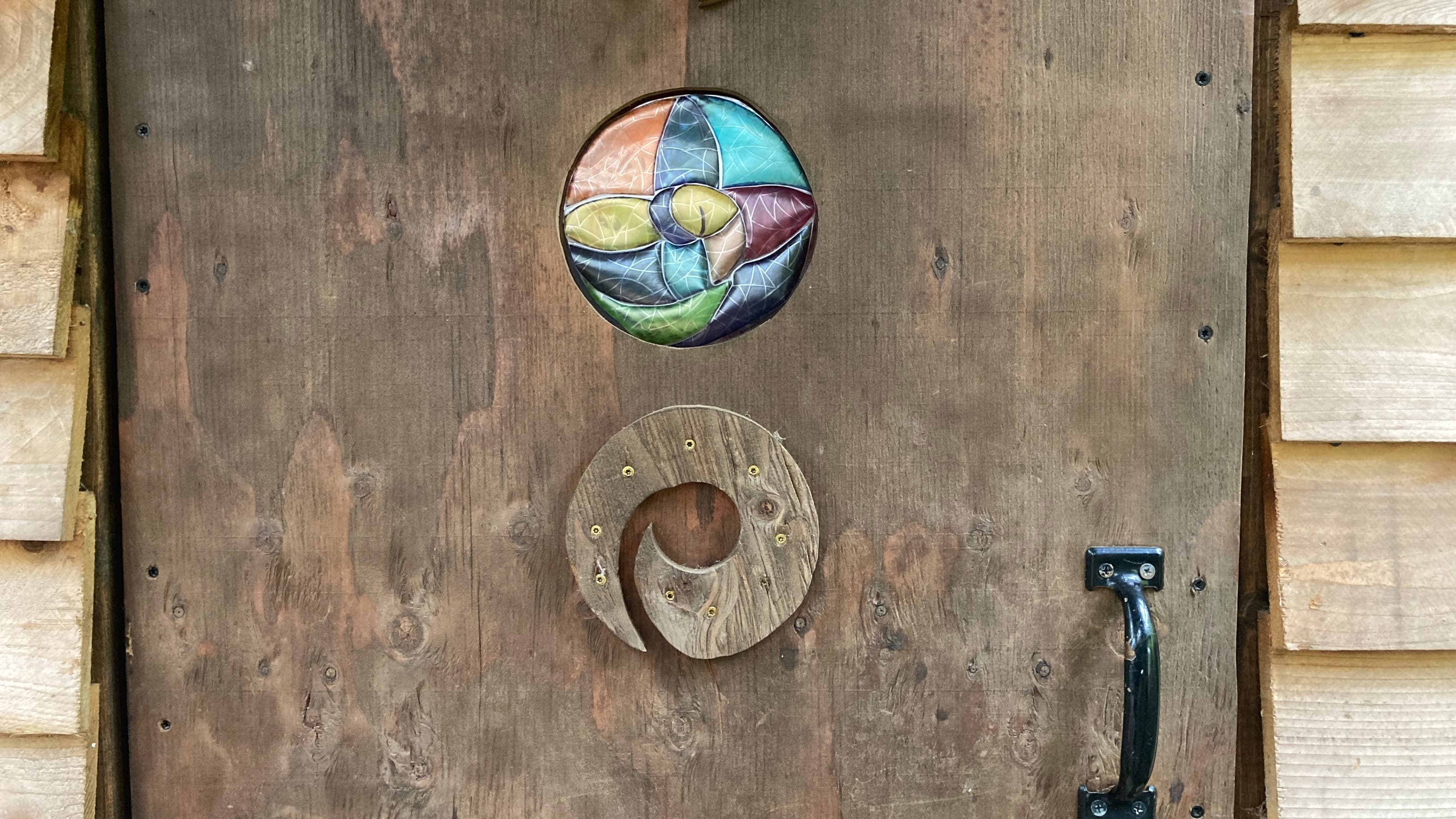 Portal window in the door with colorful and carved elements.