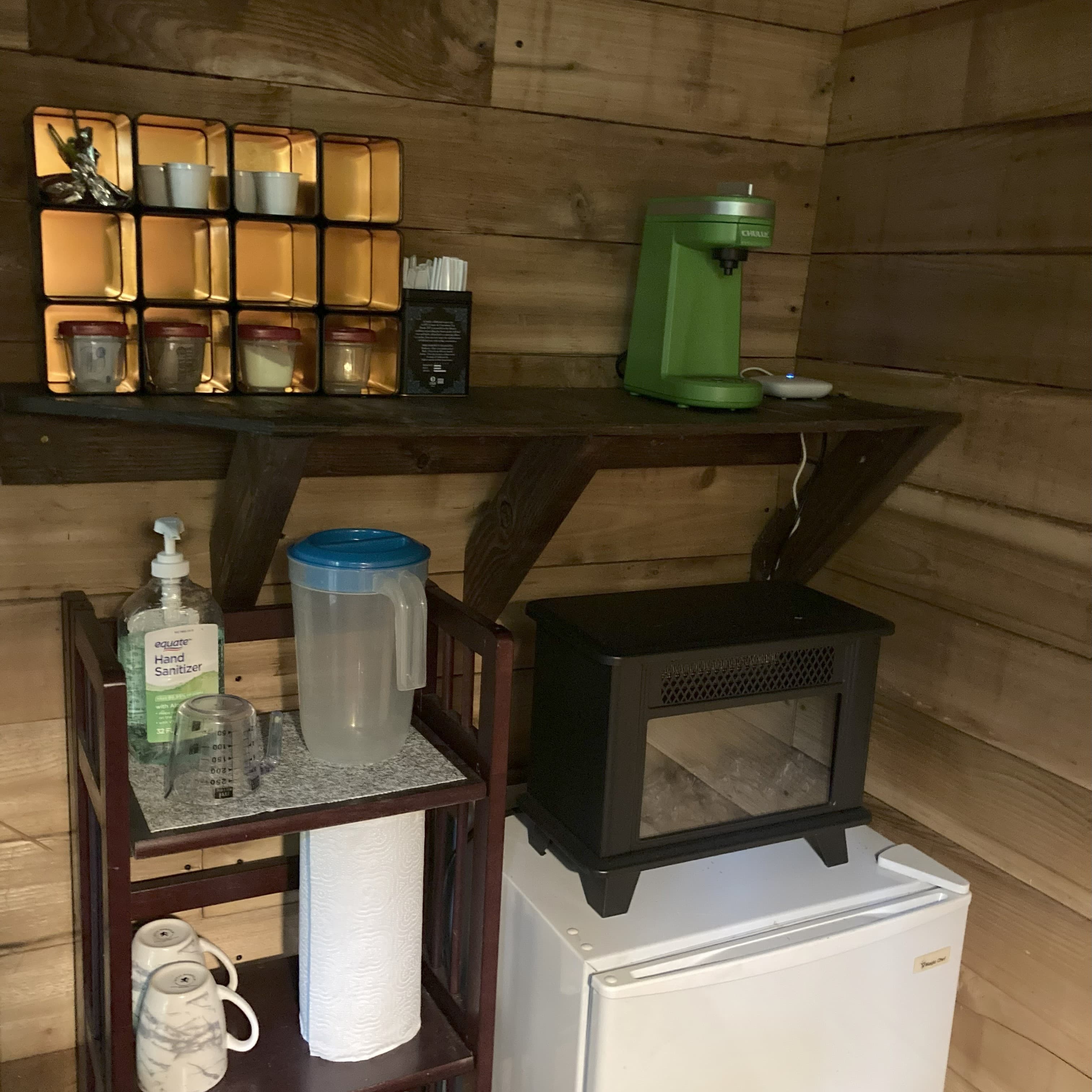 Electric fireplace and mini fridge, coffee and tea.