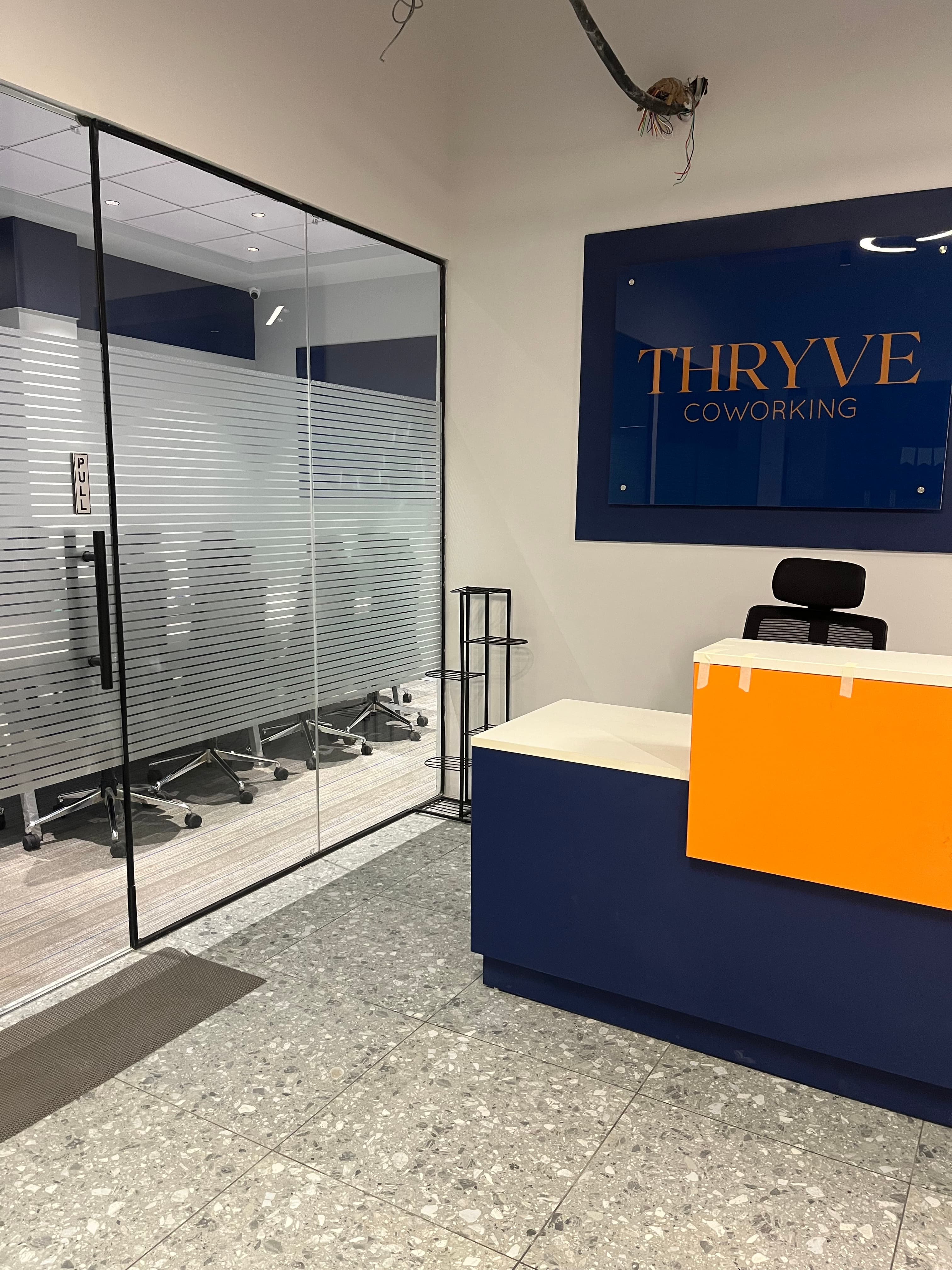  A sleek and modern reception area at Thryve Coworking, designed with a professional yet welcoming aesthetic. 