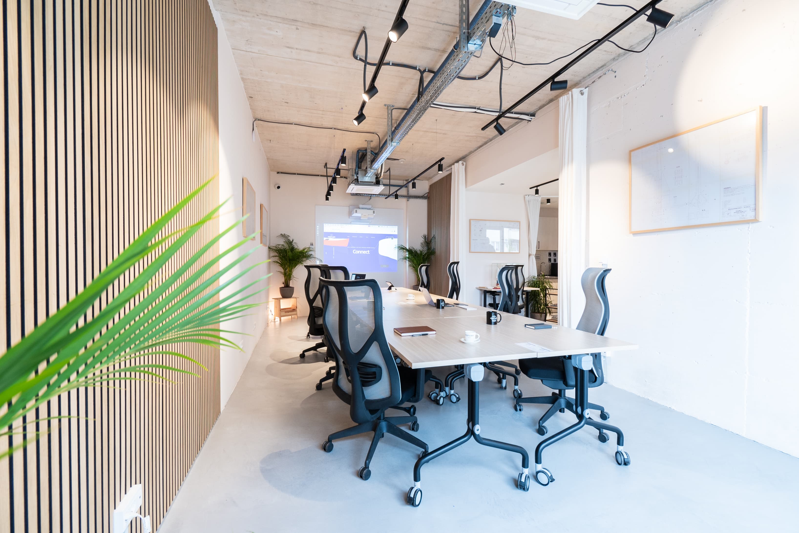 Sleek open desk area with wood panel accents and comfortable seating, offering flexibility.