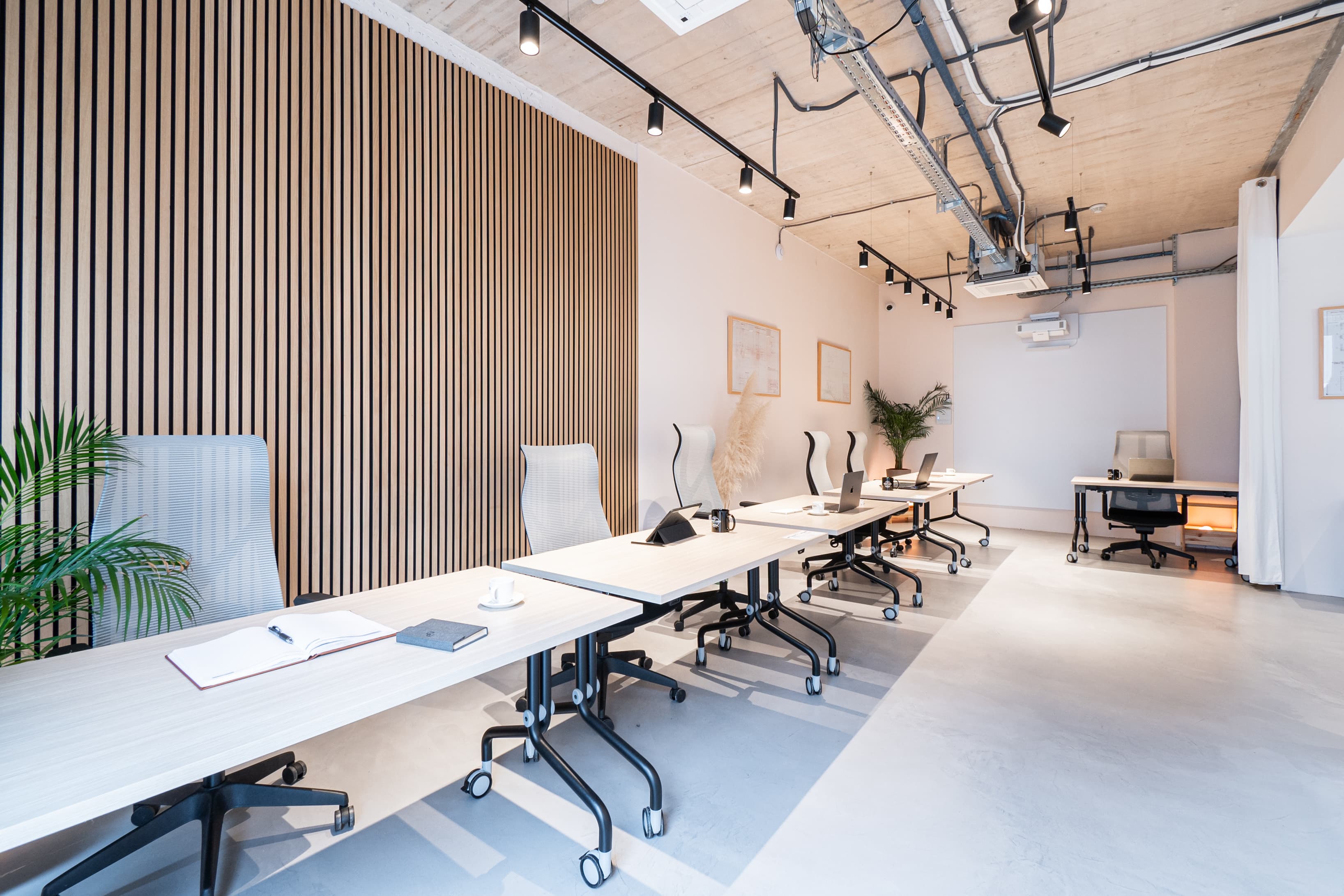 Spacious work area with contemporary design and multiple desks, ideal for group projects or events.