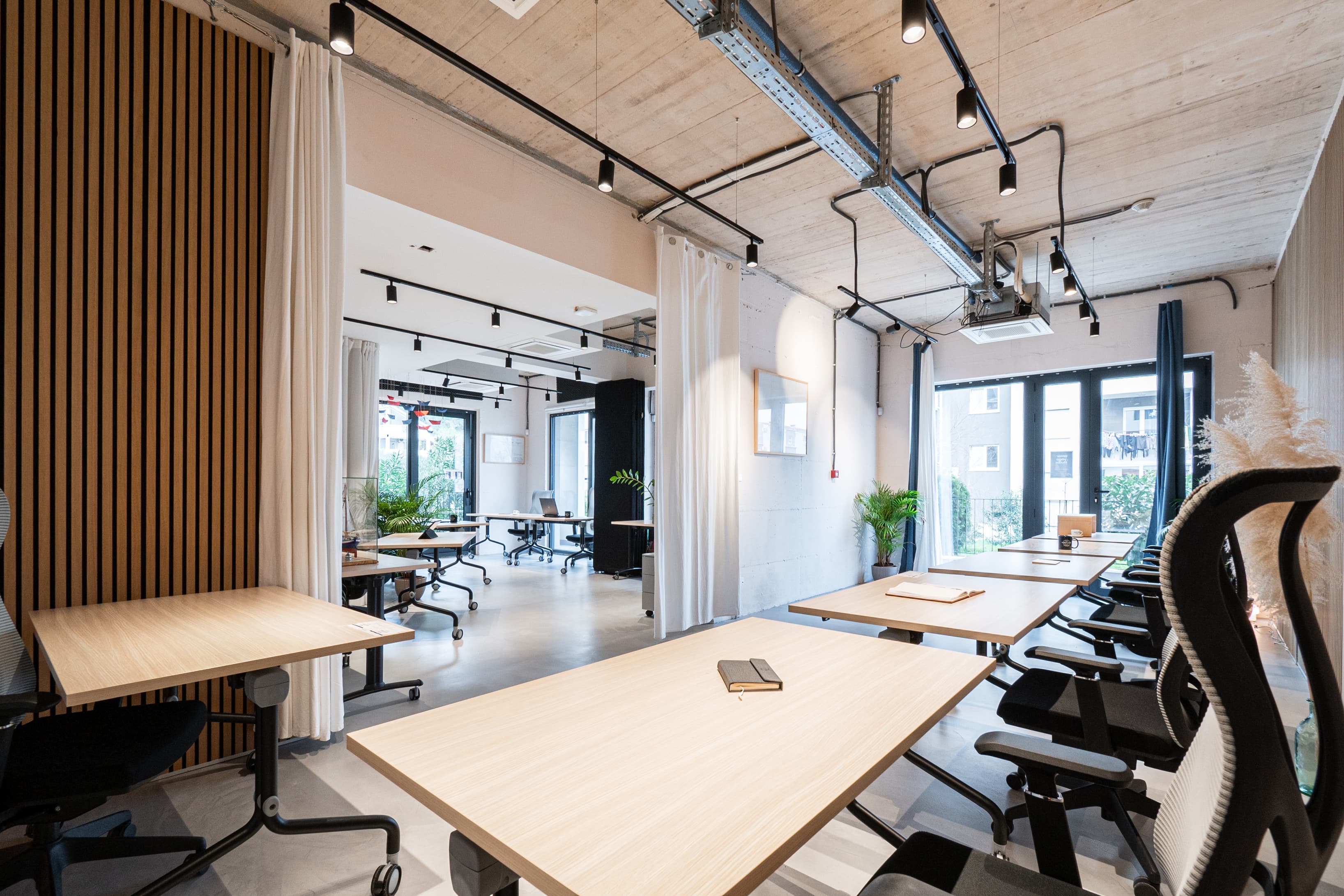 Bright and adaptable shared space with floor-to-ceiling windows and curtains for privacy.