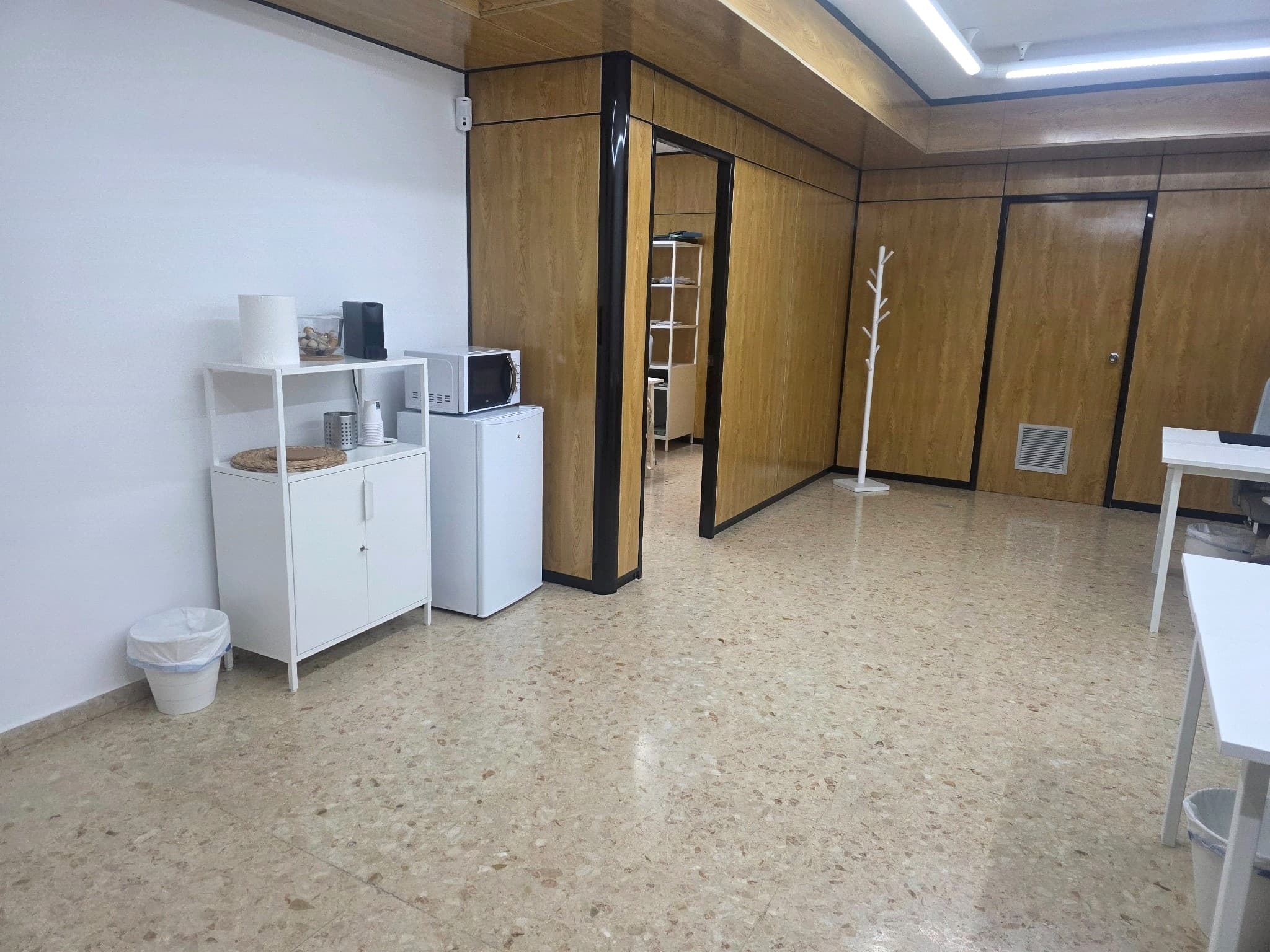 Zona común equipada con nevera, microondas y espacio para café, disponible para los usuarios del coworking.