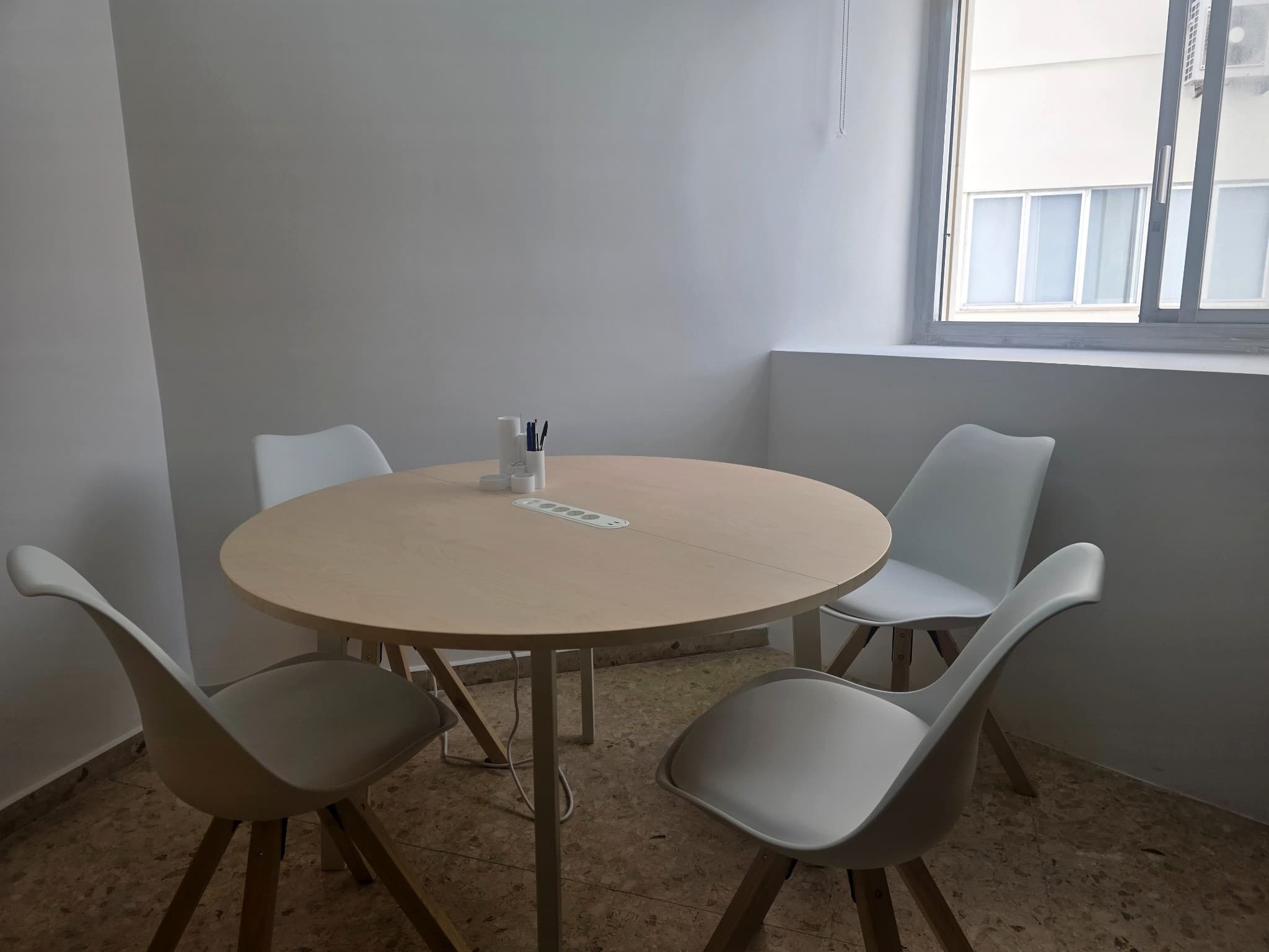 Sala de juntas con luz natural y capacidad para pequeñas reuniones de trabajo.