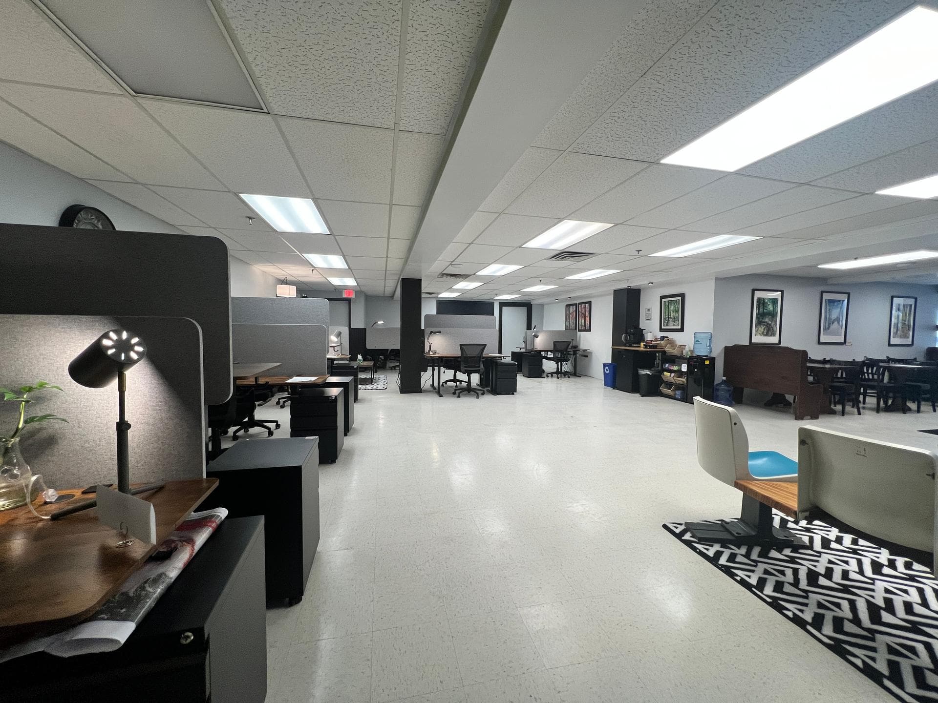 Open floor plan showing hot desks, desk lamps, coffee bar, and communal dining area at Slope Space coworking in Killington, V Open floor plan showing hot desks, desk lamps, coffee bar, and communal dining area at Slope Space coworking in Killington, V