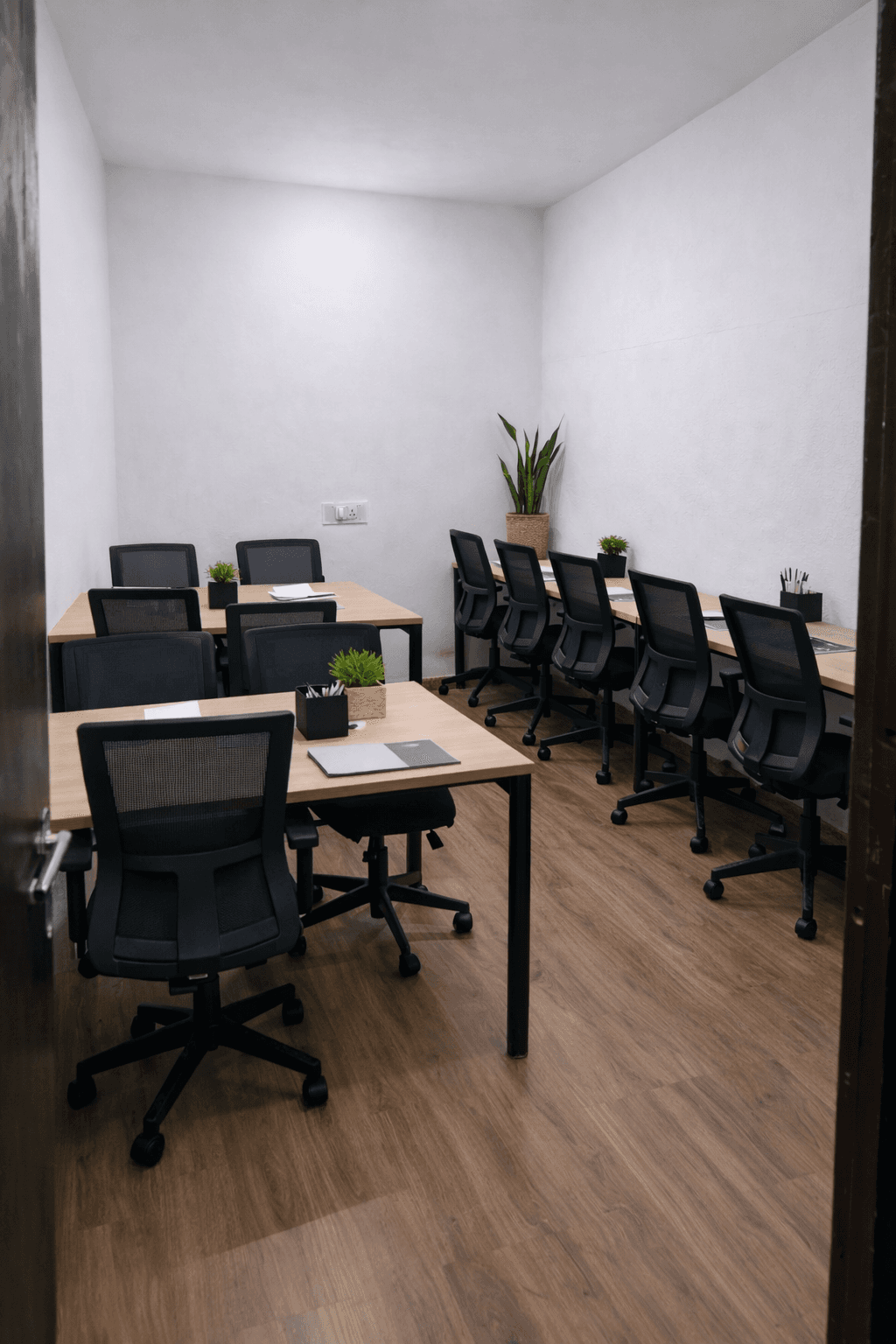 A modern and well-organized office setup at Leo Workspace, featuring ergonomic black swivel chairs and sturdy wooden-top desk
