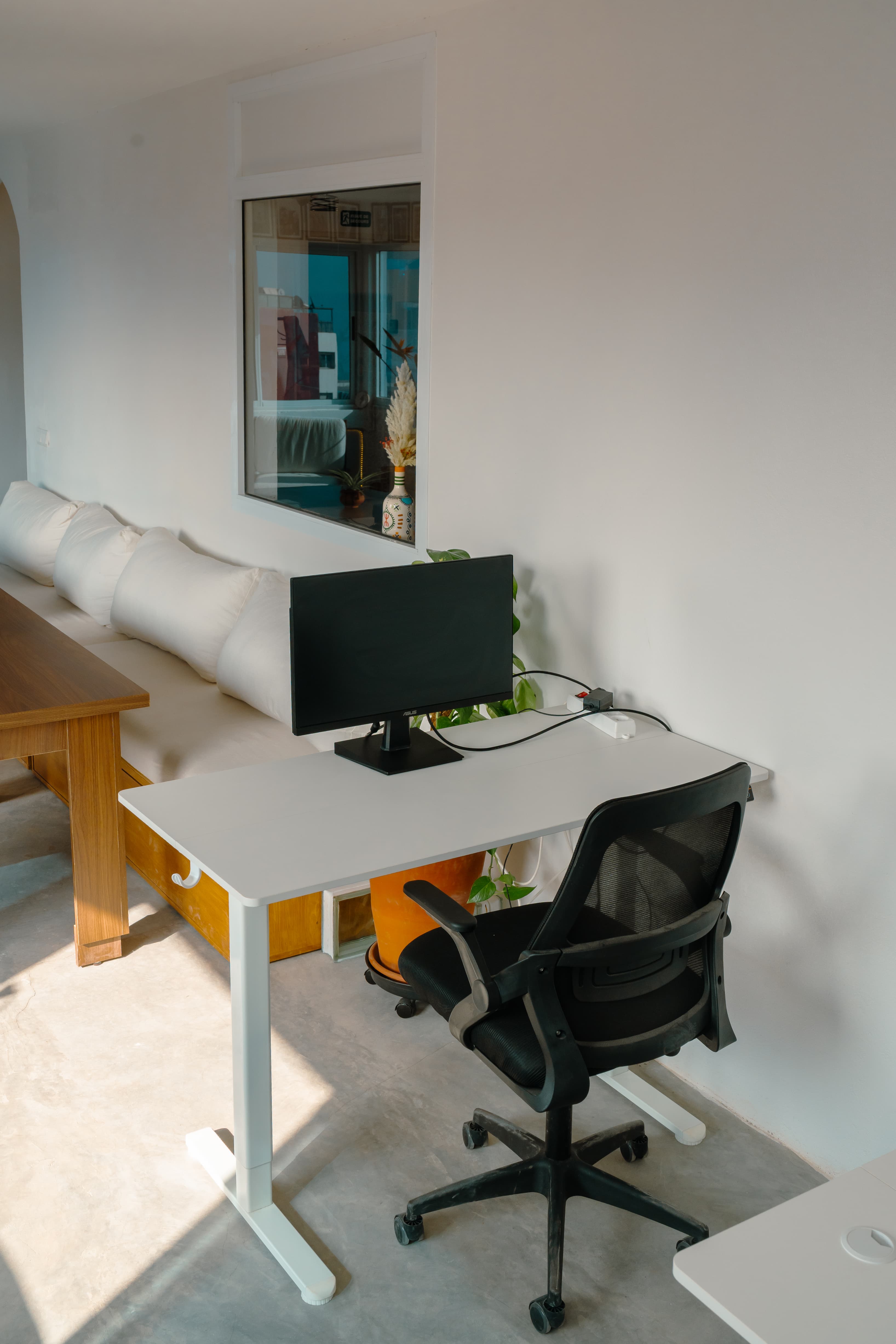 Height-adjustable desk at Amsiln Studio with external monitor—sit or stand, plug in, and work comfortably all day.
