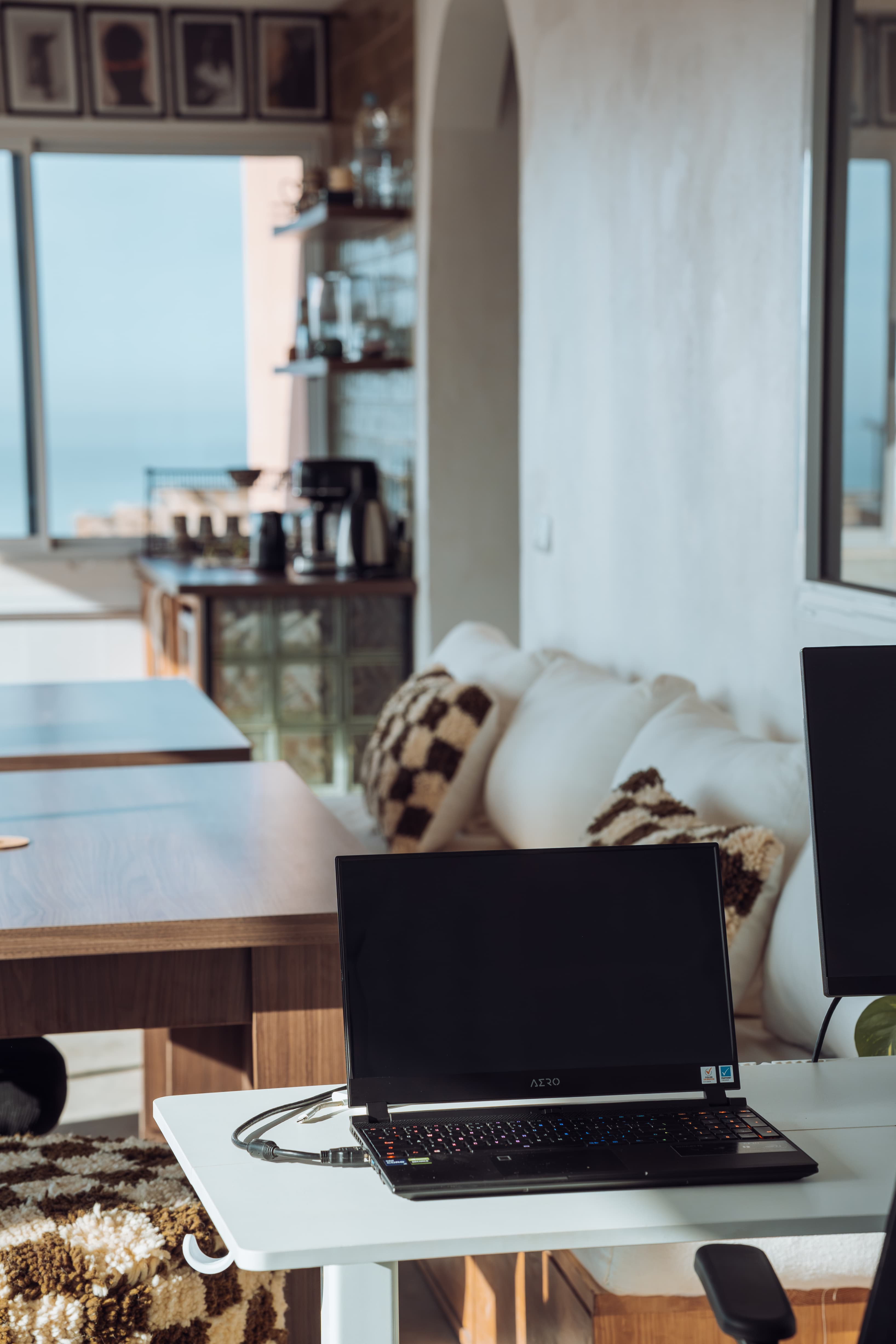 Relaxed corner at Amsiln Studio with laptop, cozy sofa, coffee station, and natural light—work at your own pace comfortably.