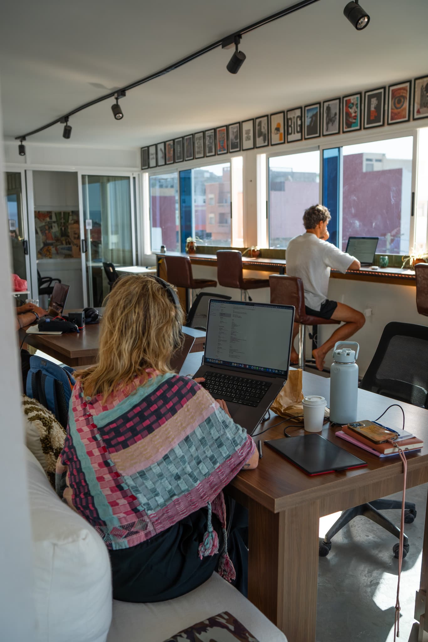 A busy day at Amsiln Studio, members working across the space with floor-to-ceiling windows letting in Atlantic light and ene