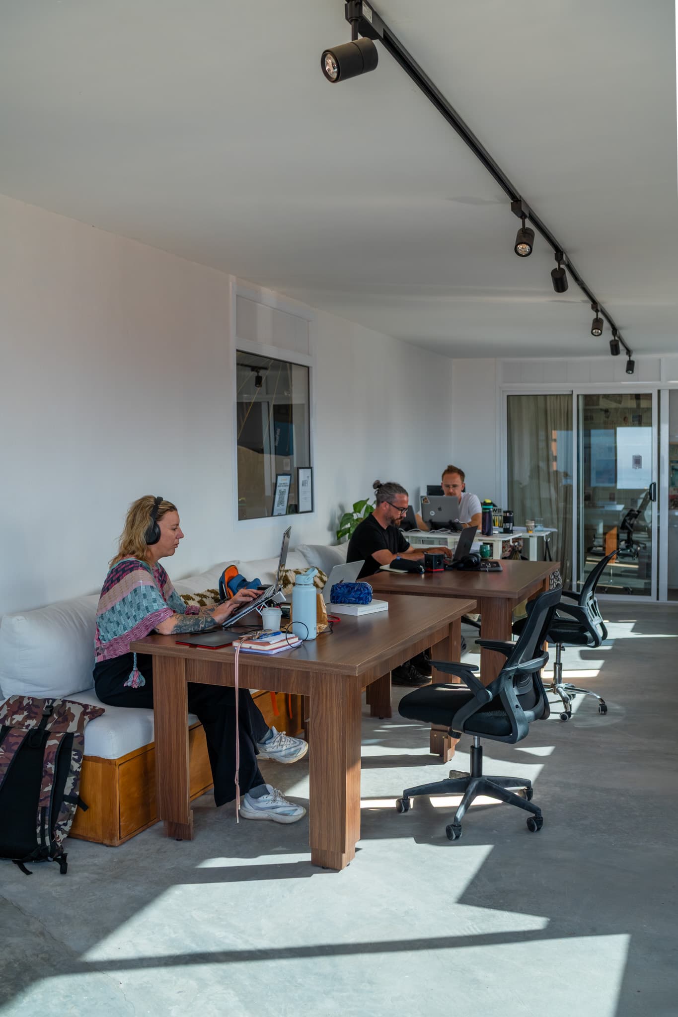 Members working side by side at Amsiln Studio, a calm, focused space with natural light and just enough community around.