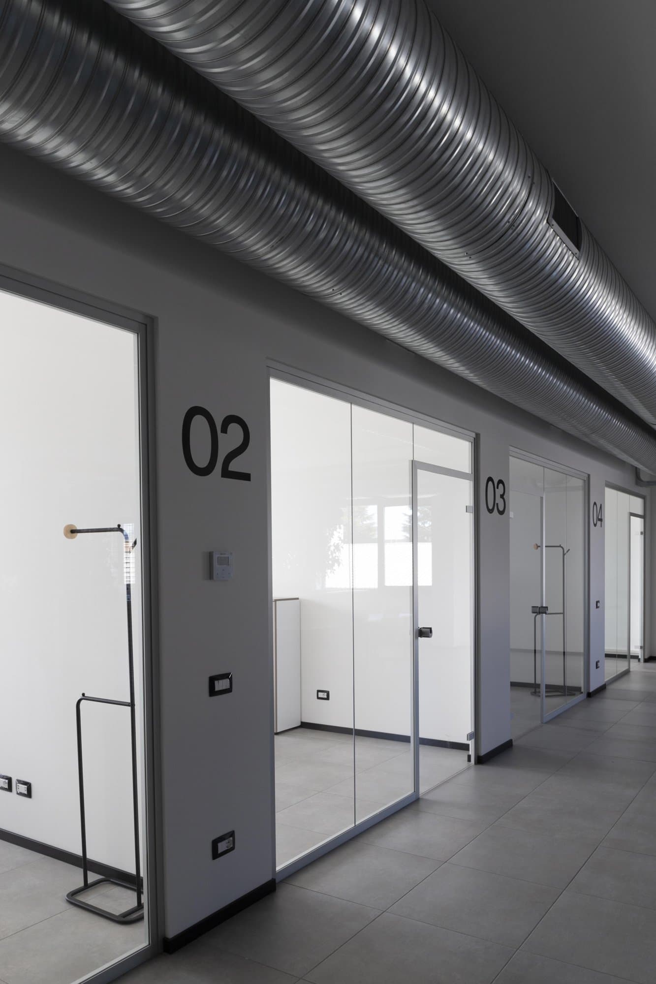 Glass-walled private office with coat stand. Glass-walled private office with coat stand.