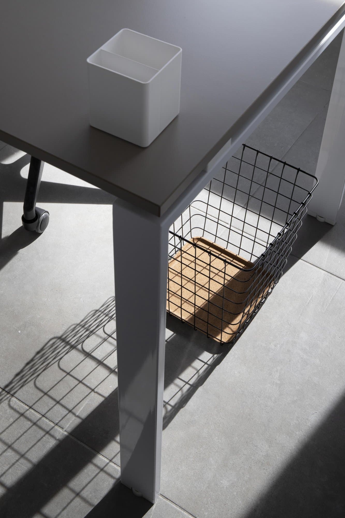 Desk detail with storage basket. Desk detail with storage basket.
