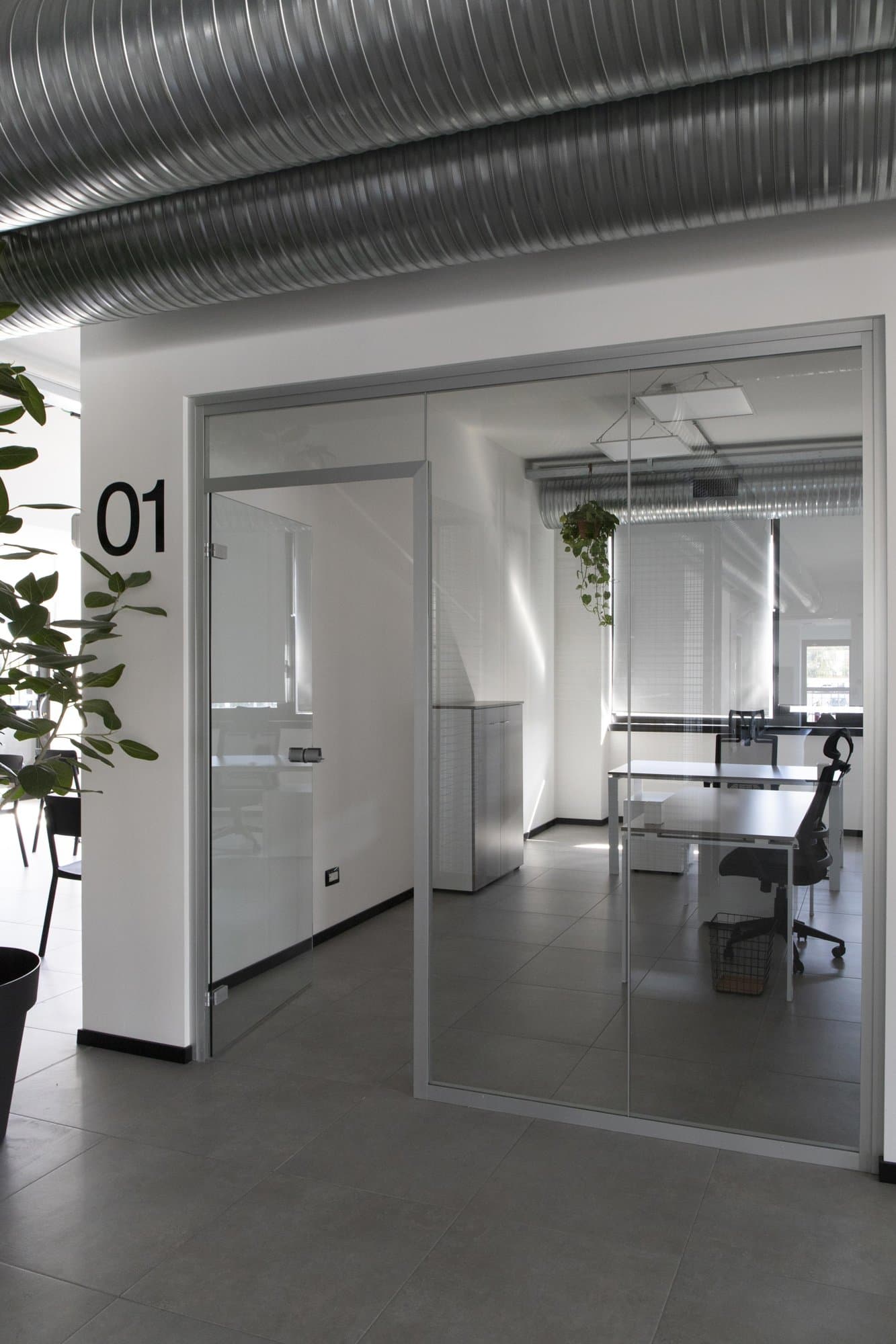Glass-walled private office with workstations. Glass-walled private office with workstations.