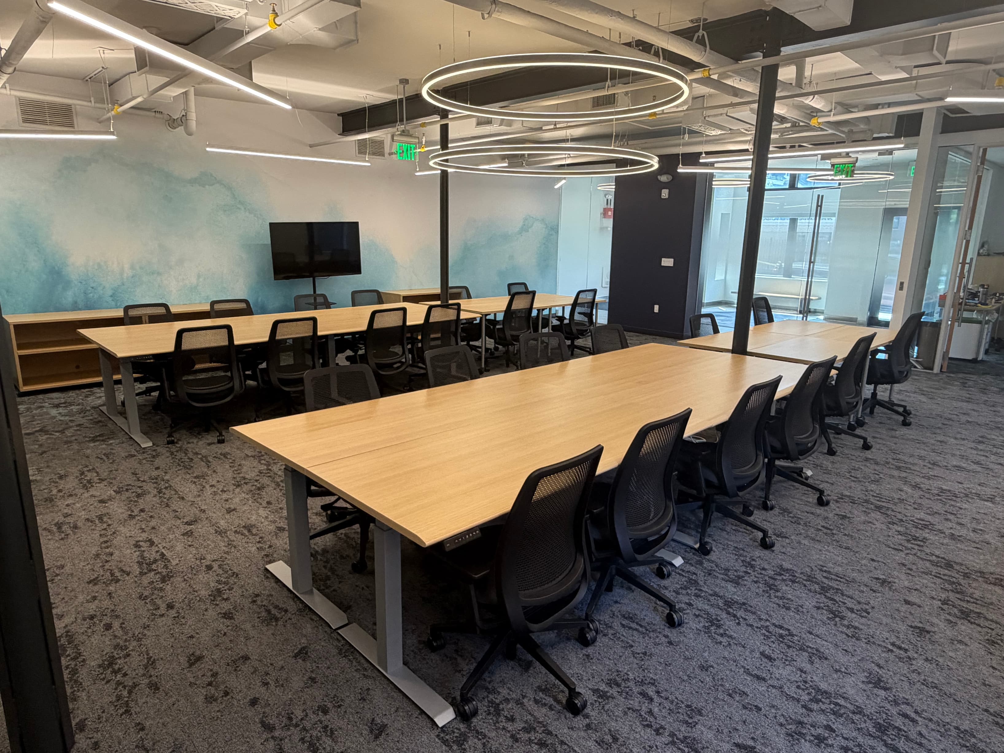 Shared co-working space with wall mount TV access Shared co-working space with wall mount TV access