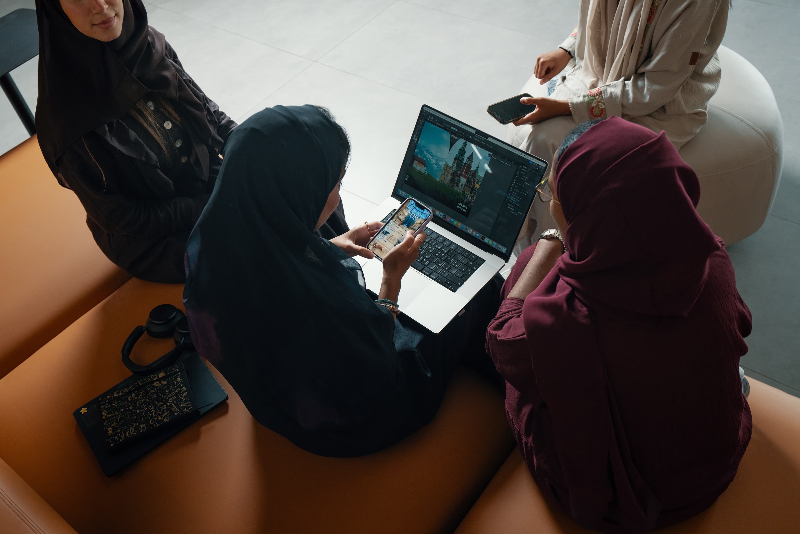 Collaborative Workspace: An image showing individuals engaged in discussions or using laptops in a shared area, with a modern Collaborative Workspace: An image showing individuals engaged in discussions or using laptops in a shared area, with a modern