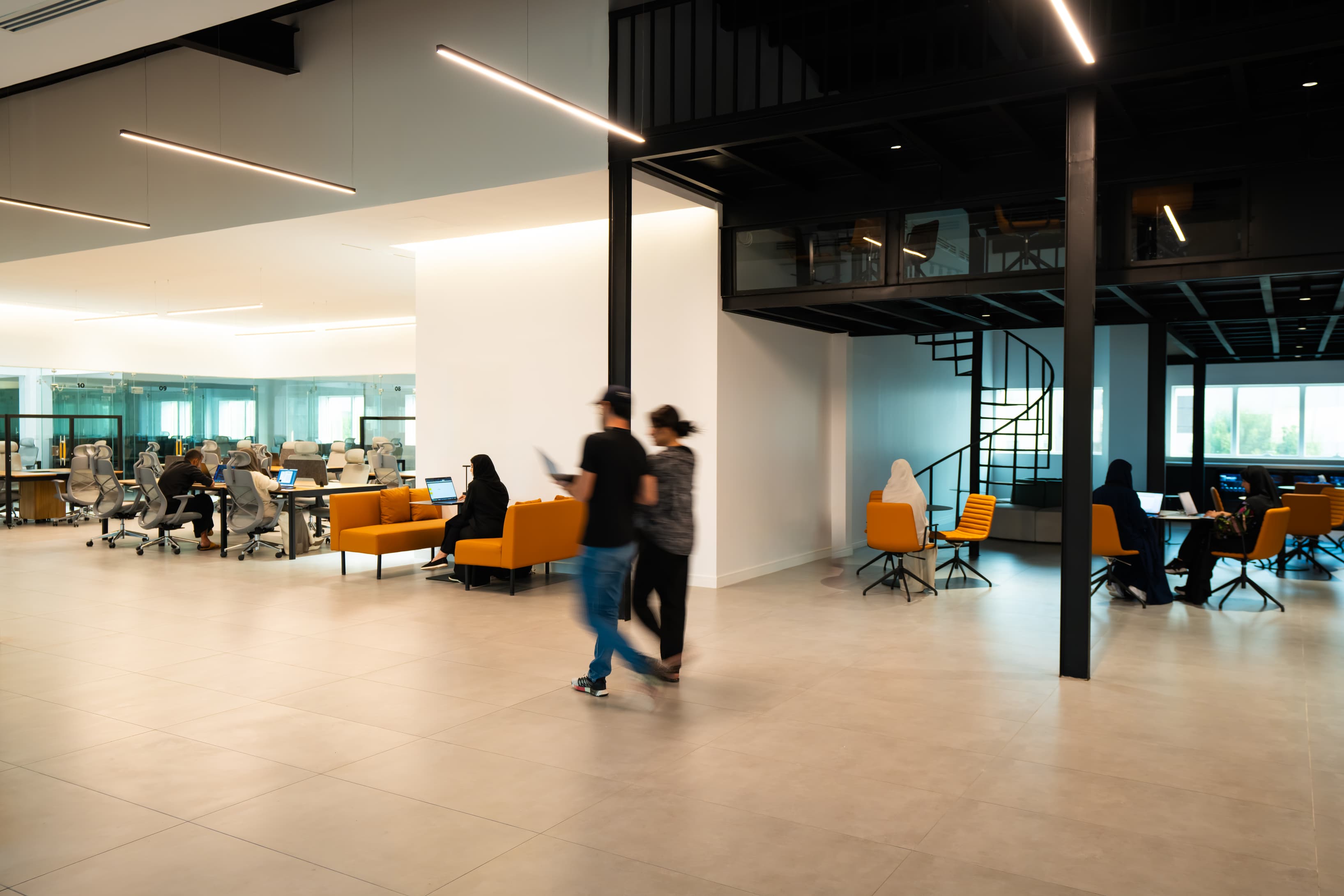 Open Space with Movement: An image capturing individuals walking through a spacious, modern area, showcasing high ceilings an Open Space with Movement: An image capturing individuals walking through a spacious, modern area, showcasing high ceilings an