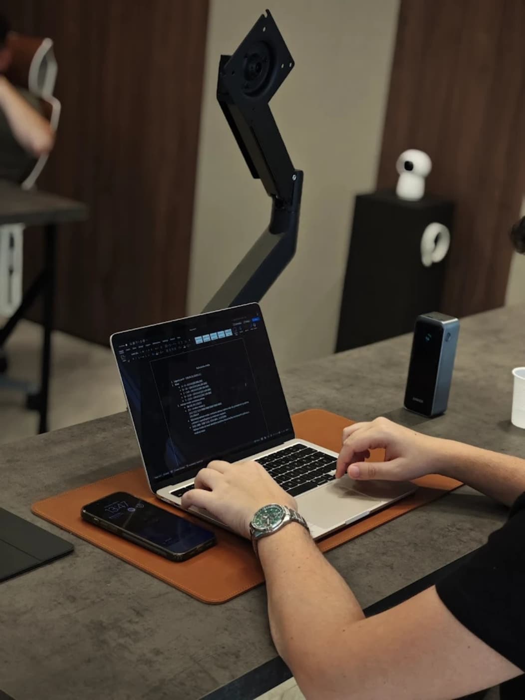 Member working on a laptop at a shared desk in the workspace