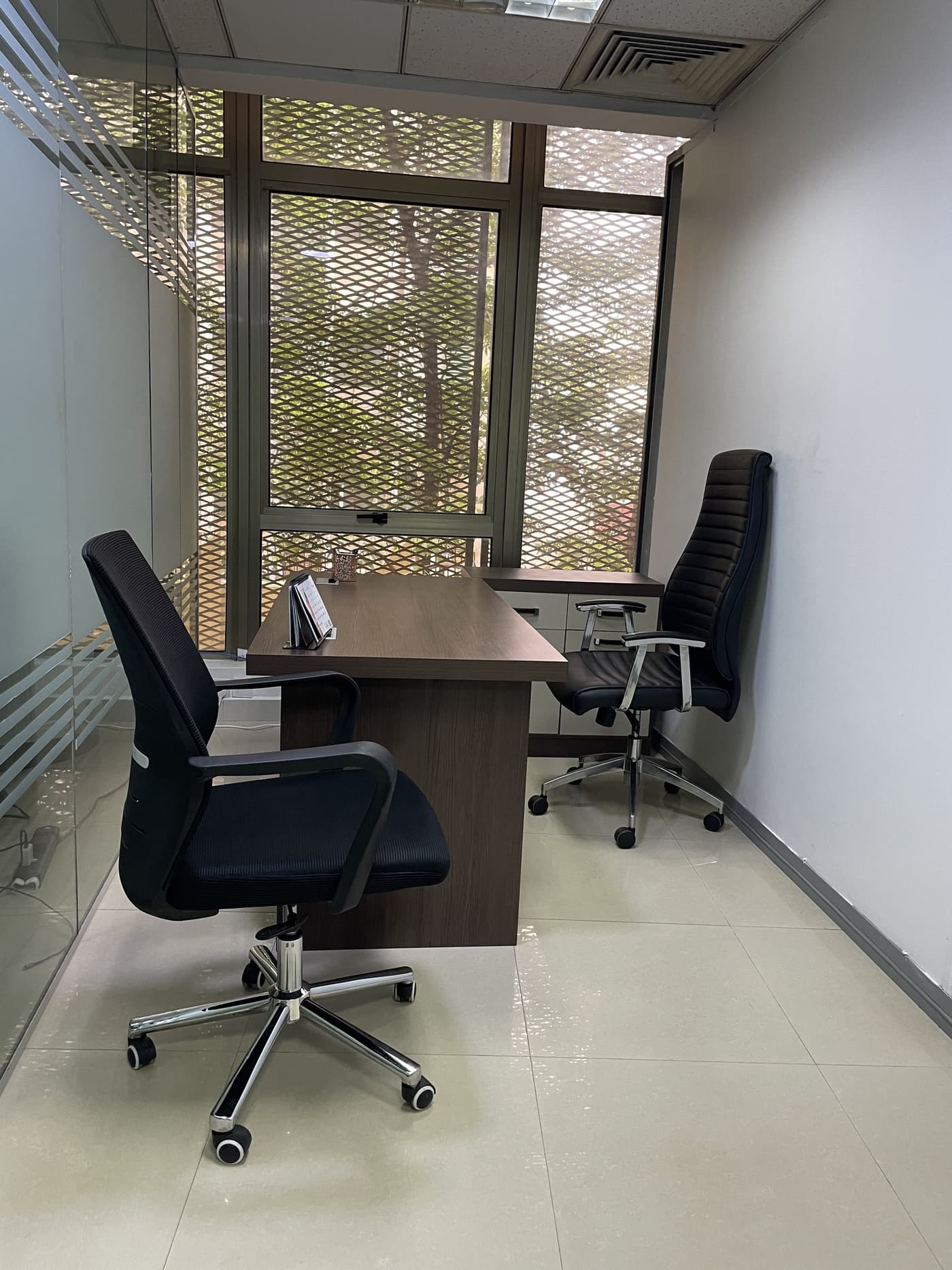 Ready to use private workspace, Stylish furnished office with desk, visitor seating, and large windows offering calm outview Ready to use private workspace, Stylish furnished office with desk, visitor seating, and large windows offering calm outview