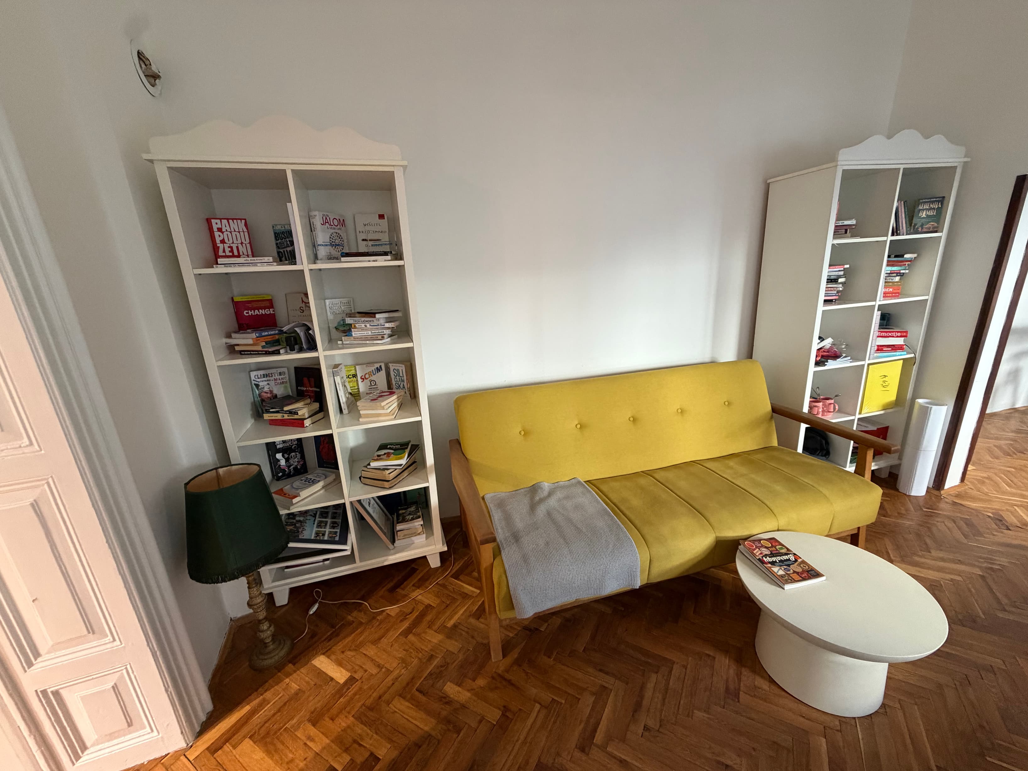 Library Lounge A cozy corner with a sunny yellow sofa and shelves of books on entrepreneurship, psychology, and business.