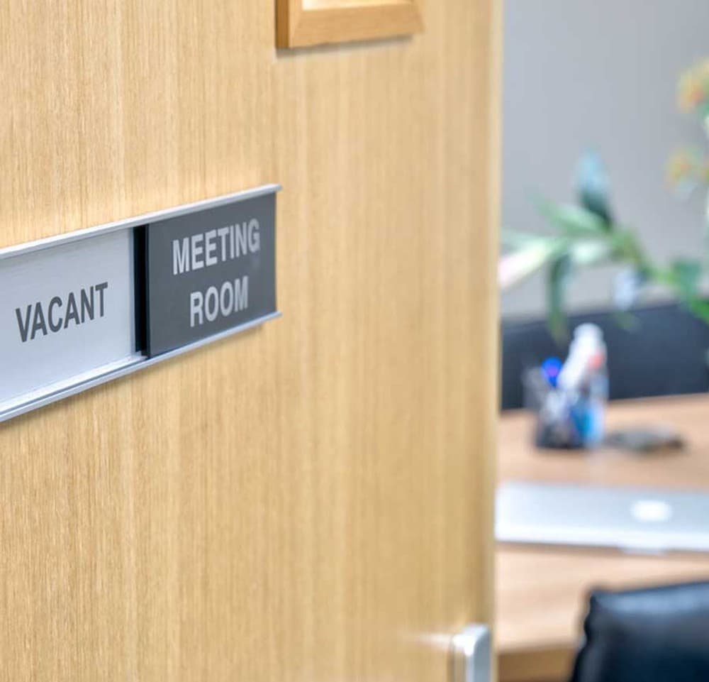 Meeting room — Boardroom table with laptop, seating for client meeting Meeting room — Boardroom table with laptop, seating for client meeting