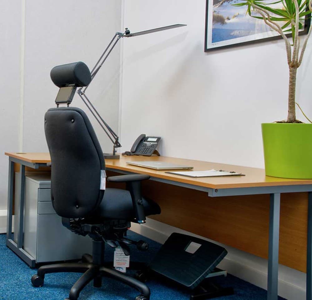 Furnished office — Typical office setup with desk, ergonomic chair, phone, and desk lamp Furnished office — Typical office setup with desk, ergonomic chair, phone, and desk lamp