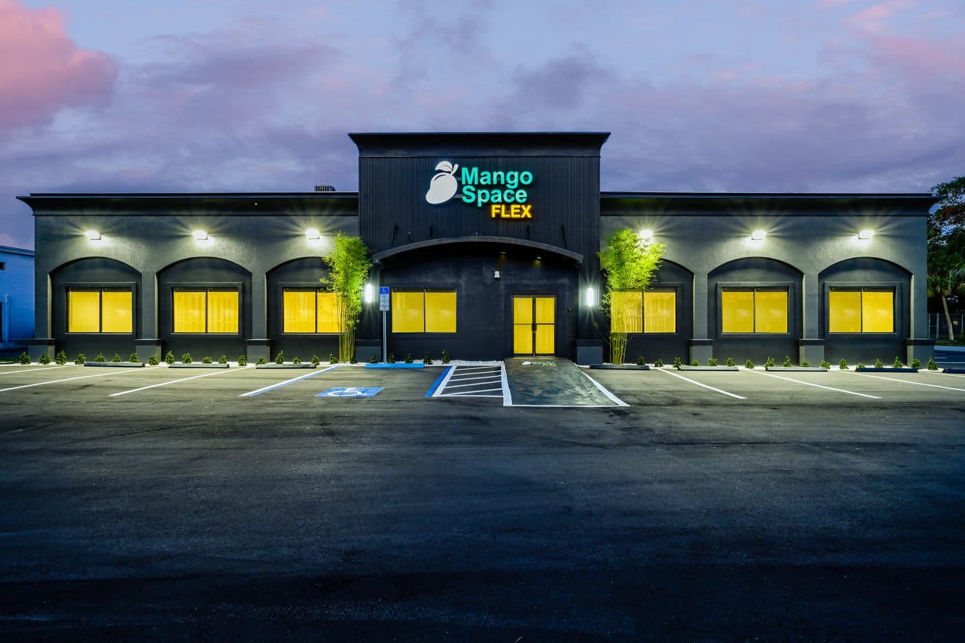 Mango Space Westshore at dusk: a single-story flex building with offices, warehouse and retail suites. Mango Space Westshore at dusk: a single-story flex building with offices, warehouse and retail suites.
