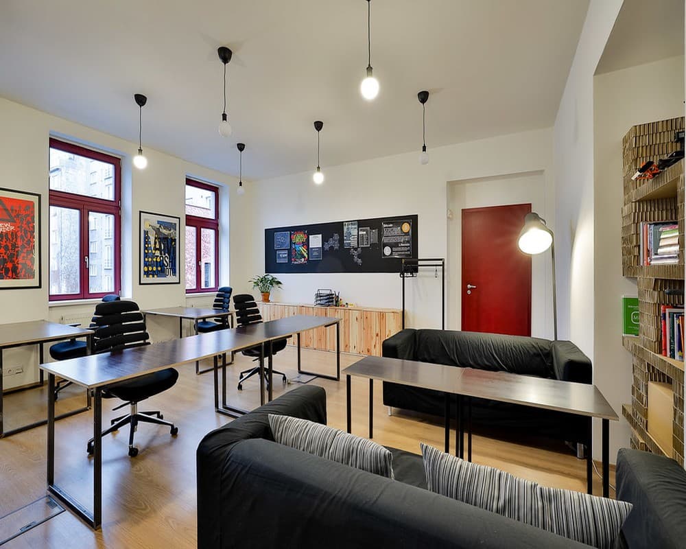 Bright open coworking area with desks, sofas, and creative wall art — perfect for focused work or informal collaboration. Bright open coworking area with desks, sofas, and creative wall art — perfect for focused work or informal collaboration.