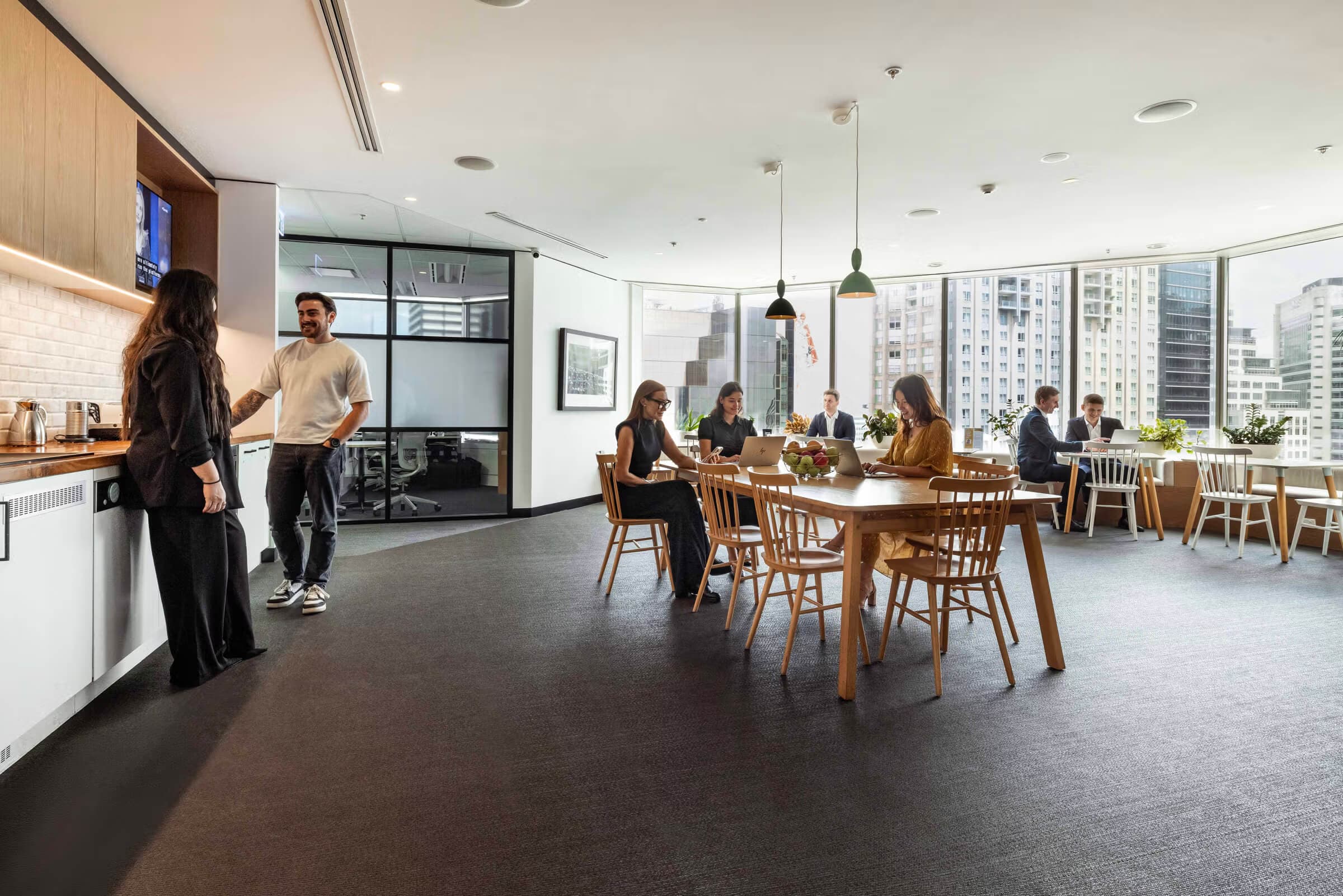 Vibrant breakout zone and team collaboration area with city views. Vibrant breakout zone and team collaboration area with city views.