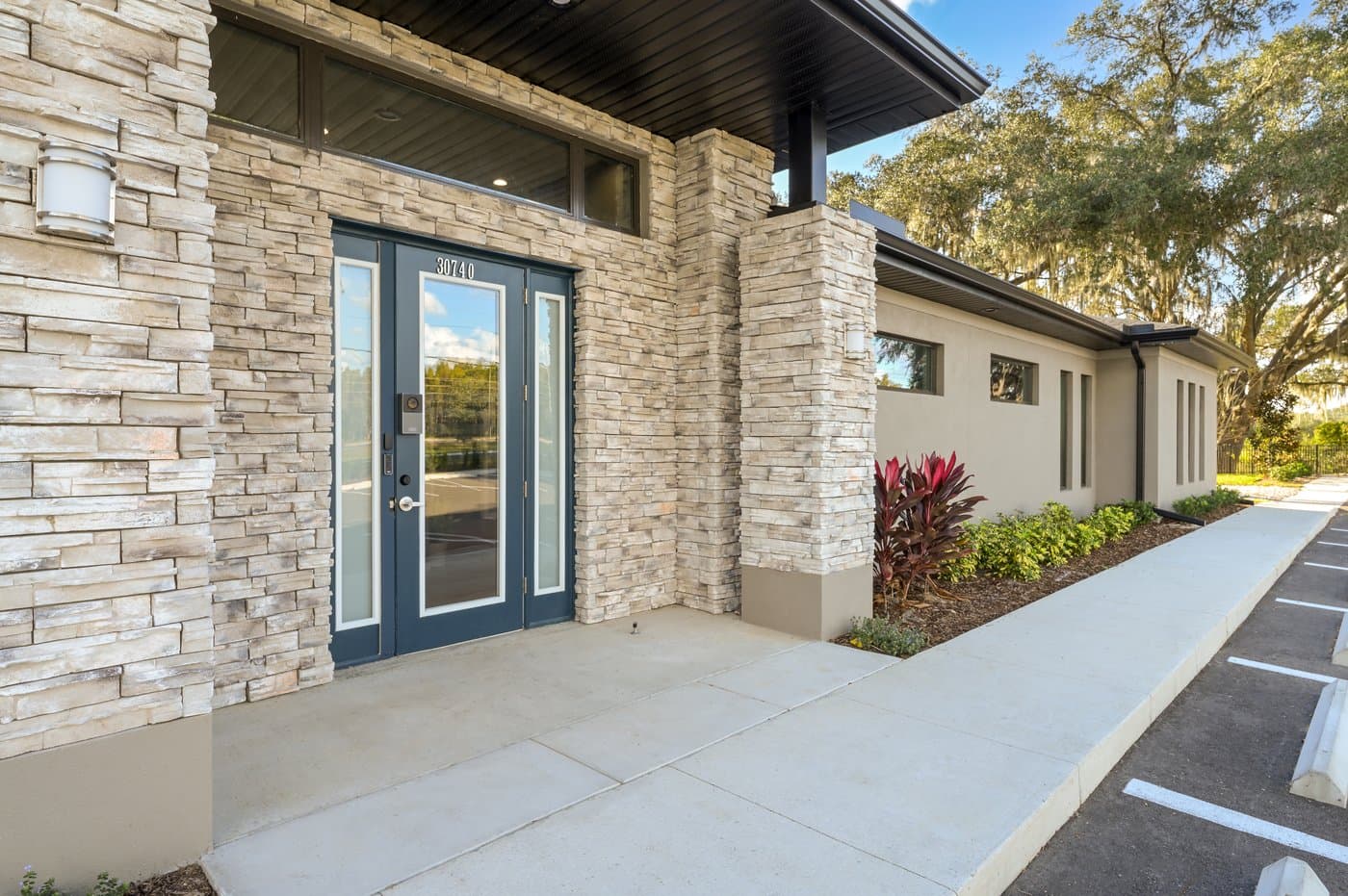 Main entrance with stone facade and glass doors; members enter 24/7 with keyless access. Main entrance with stone facade and glass doors; members enter 24/7 with keyless access.