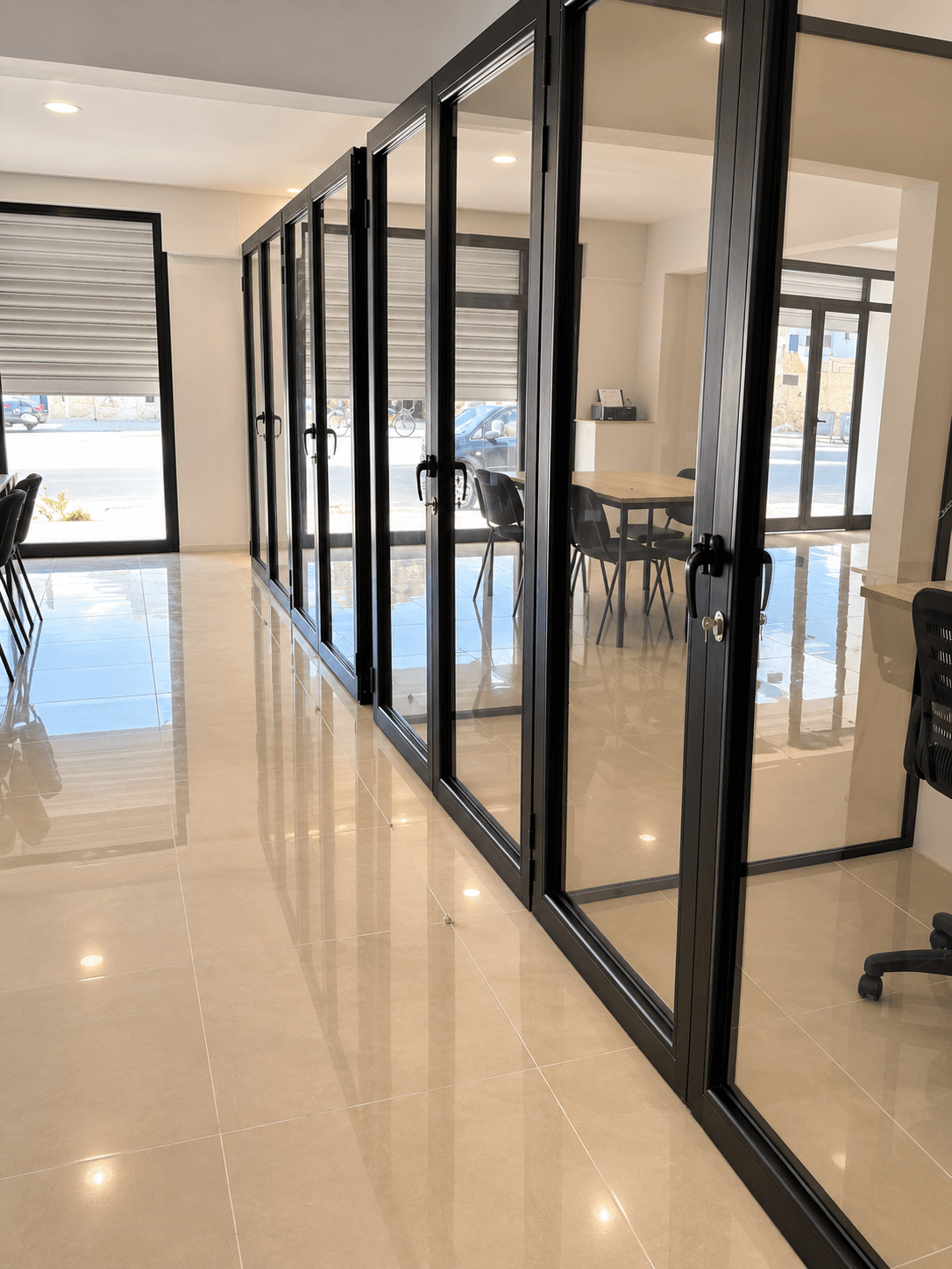 Glass-enclosed workspaces with natural daylight, modern black framing, and a clean professional atmosphere. Glass-enclosed workspaces with natural daylight, modern black framing, and a clean professional atmosphere.