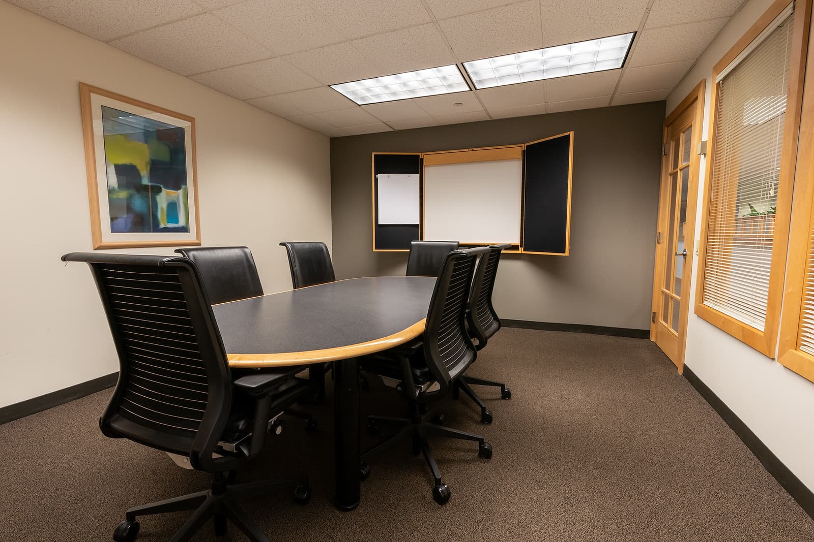 Small conference room with seating for up to six, featuring a professional setting ideal for meetings. Small conference room with seating for up to six, featuring a professional setting ideal for meetings.
