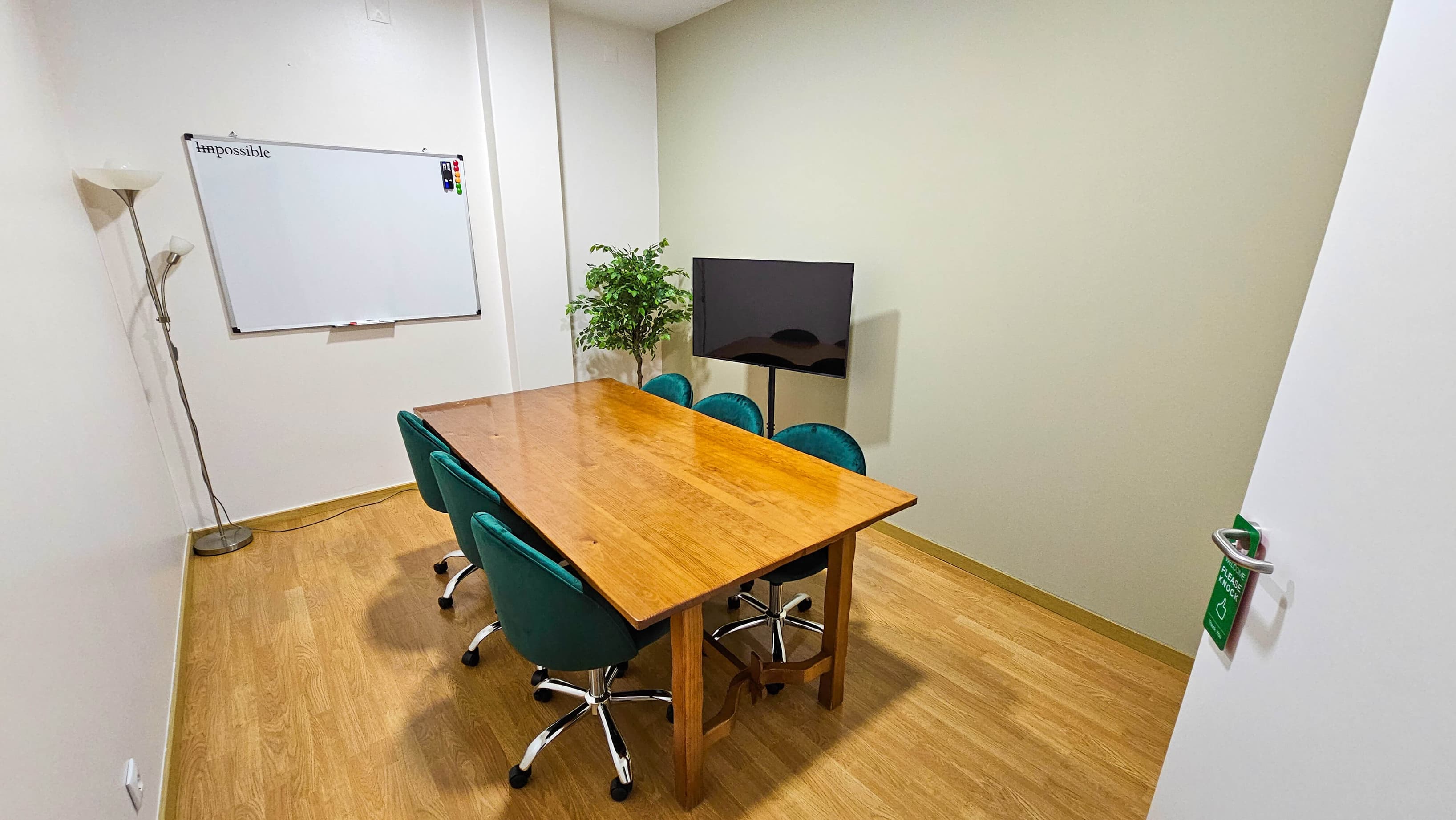Private meeting room with a wooden table, comfortable chairs, whiteboard, and screen, suitable for team meetings and client p Private meeting room with a wooden table, comfortable chairs, whiteboard, and screen, suitable for team meetings and client p