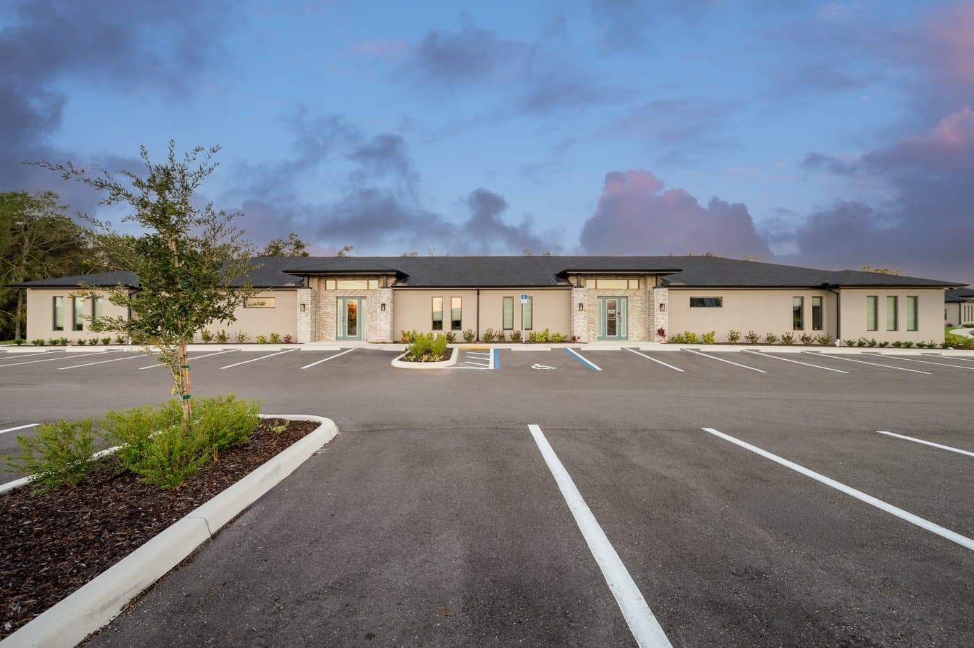 The single-story Allegra Way building at dusk, with free parking and accessible spaces at the door. The single-story Allegra Way building at dusk, with free parking and accessible spaces at the door.