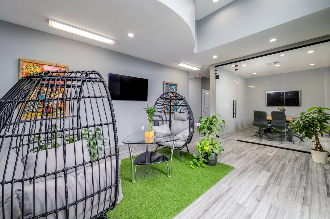 Lounge seating beside a glass-walled meeting room, a relaxed spot between calls. Lounge seating beside a glass-walled meeting room, a relaxed spot between calls.