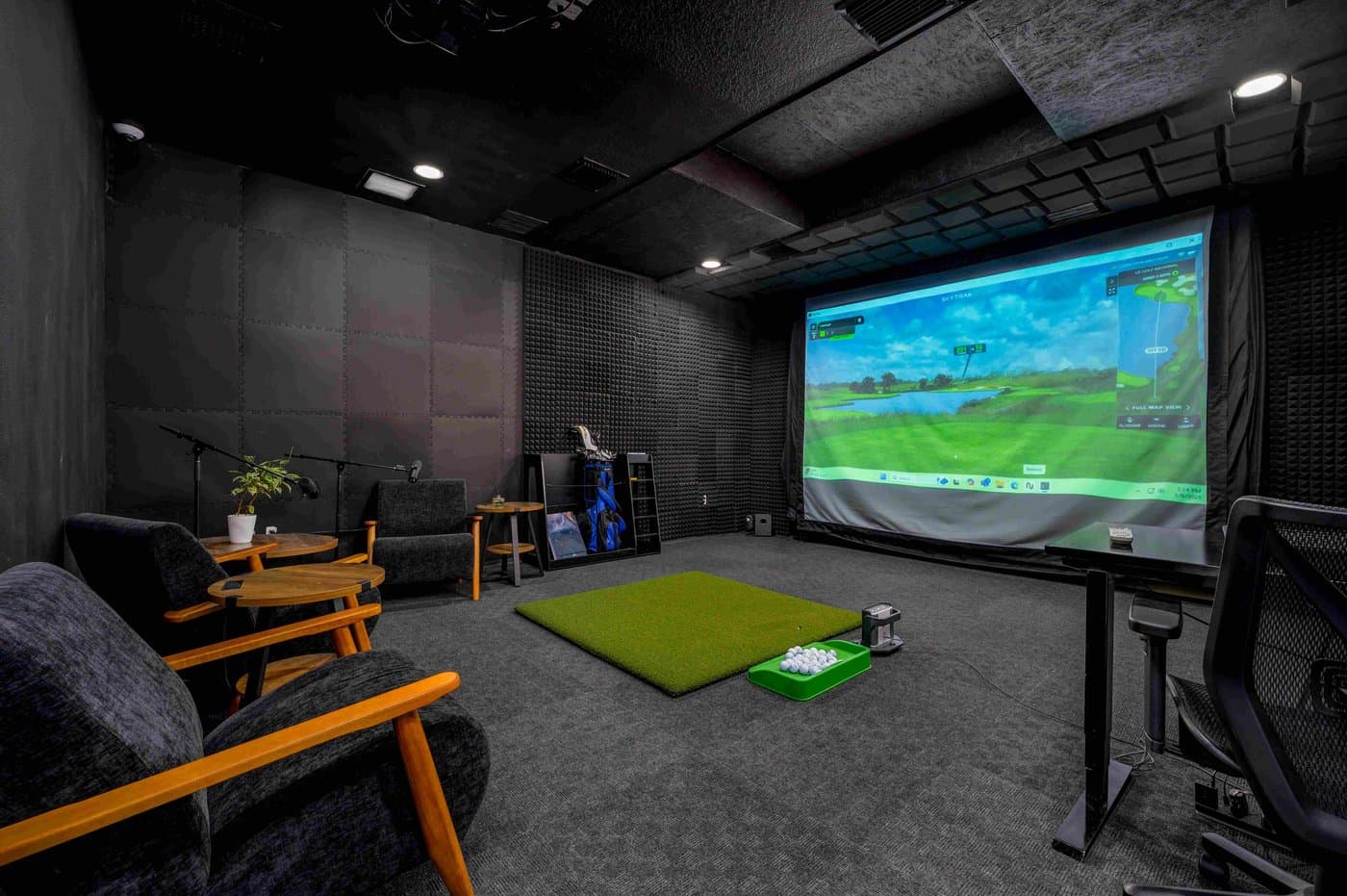 Golf simulator studio with a large screen and lounge seating, bookable by the hour. Golf simulator studio with a large screen and lounge seating, bookable by the hour.