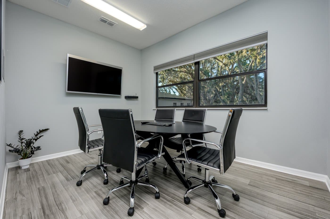 Meeting room with a large window, wall display and seating for six. Meeting room with a large window, wall display and seating for six.