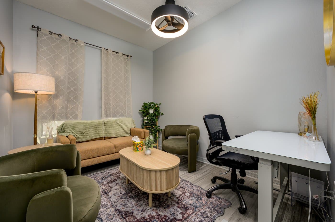 Quiet therapy room with soft seating and a desk, bookable by therapists and telehealth providers. Quiet therapy room with soft seating and a desk, bookable by therapists and telehealth providers.