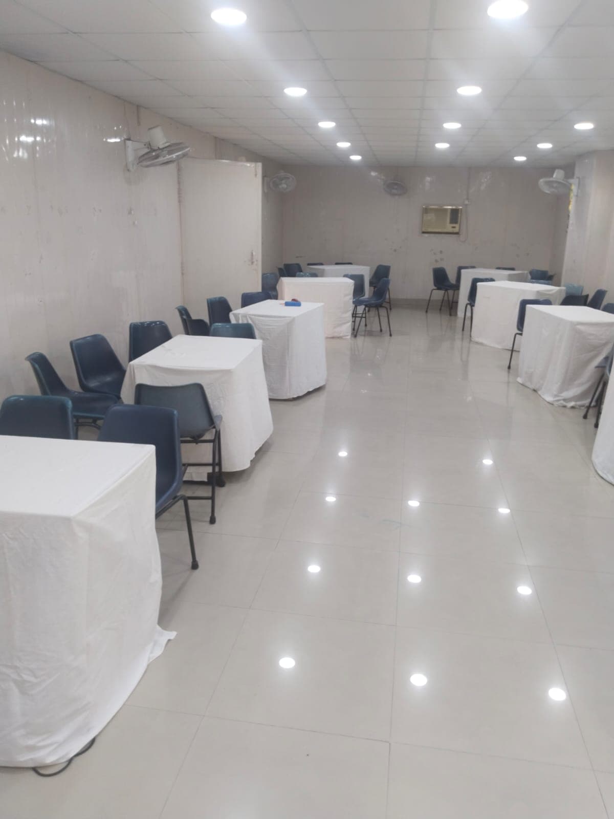 Spacious conference hall with round-table setup and bright lighting Spacious conference hall with round-table setup and bright lighting