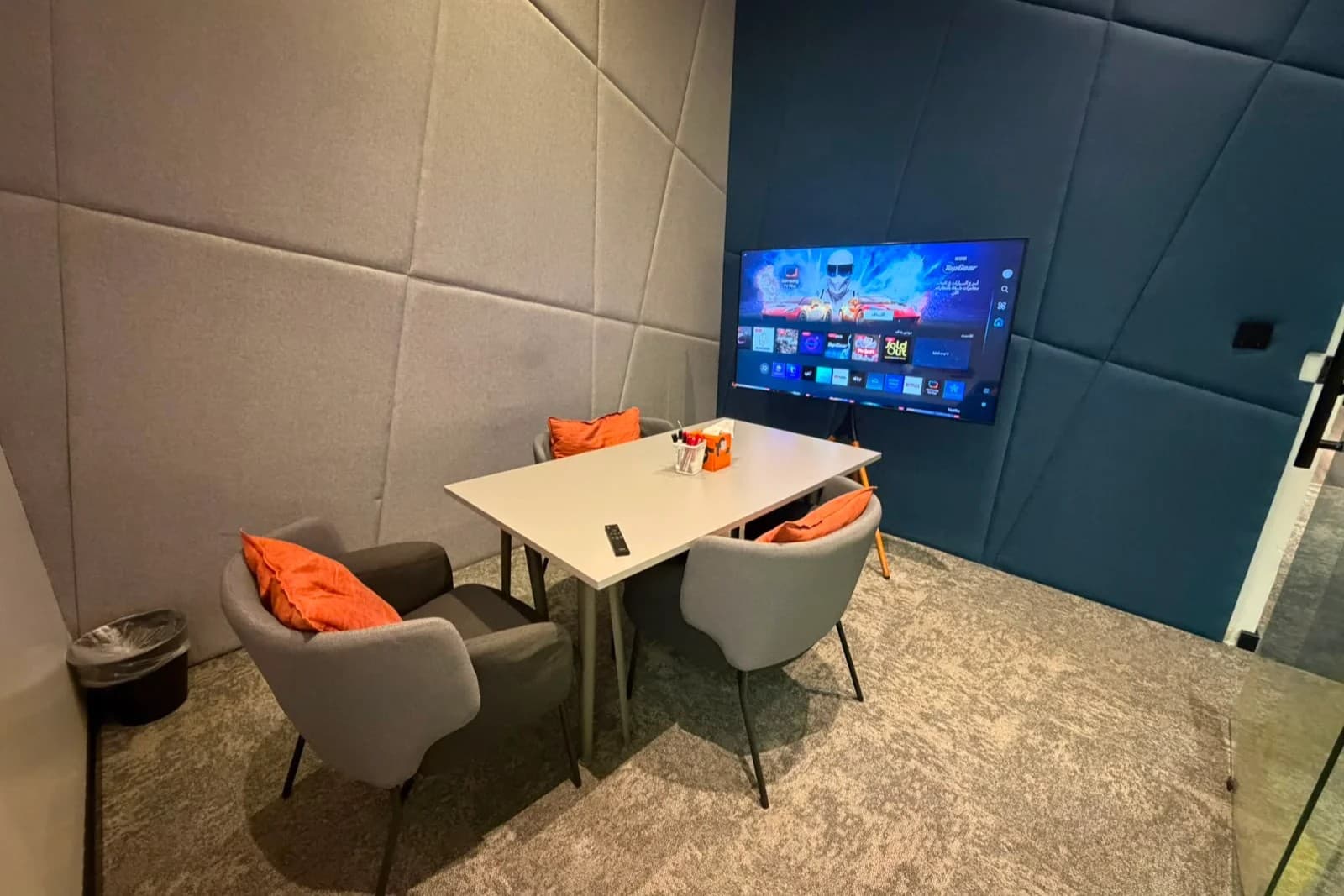 Co-zone workspace with meeting table, seating, and a wall-mounted display. Co-zone workspace with meeting table, seating, and a wall-mounted display.